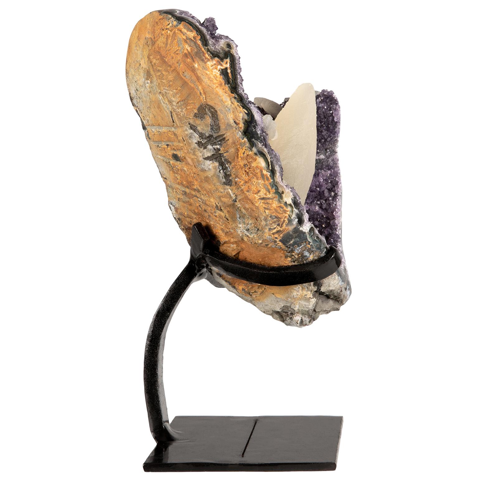 An exquisite and rare rough amethyst cluster with a calcite formation on a customized metal stand.

This stunning piece displays all the different layers of minerals. A beautiful mix of color with purple amethyst, blue agate, white quartz and the
