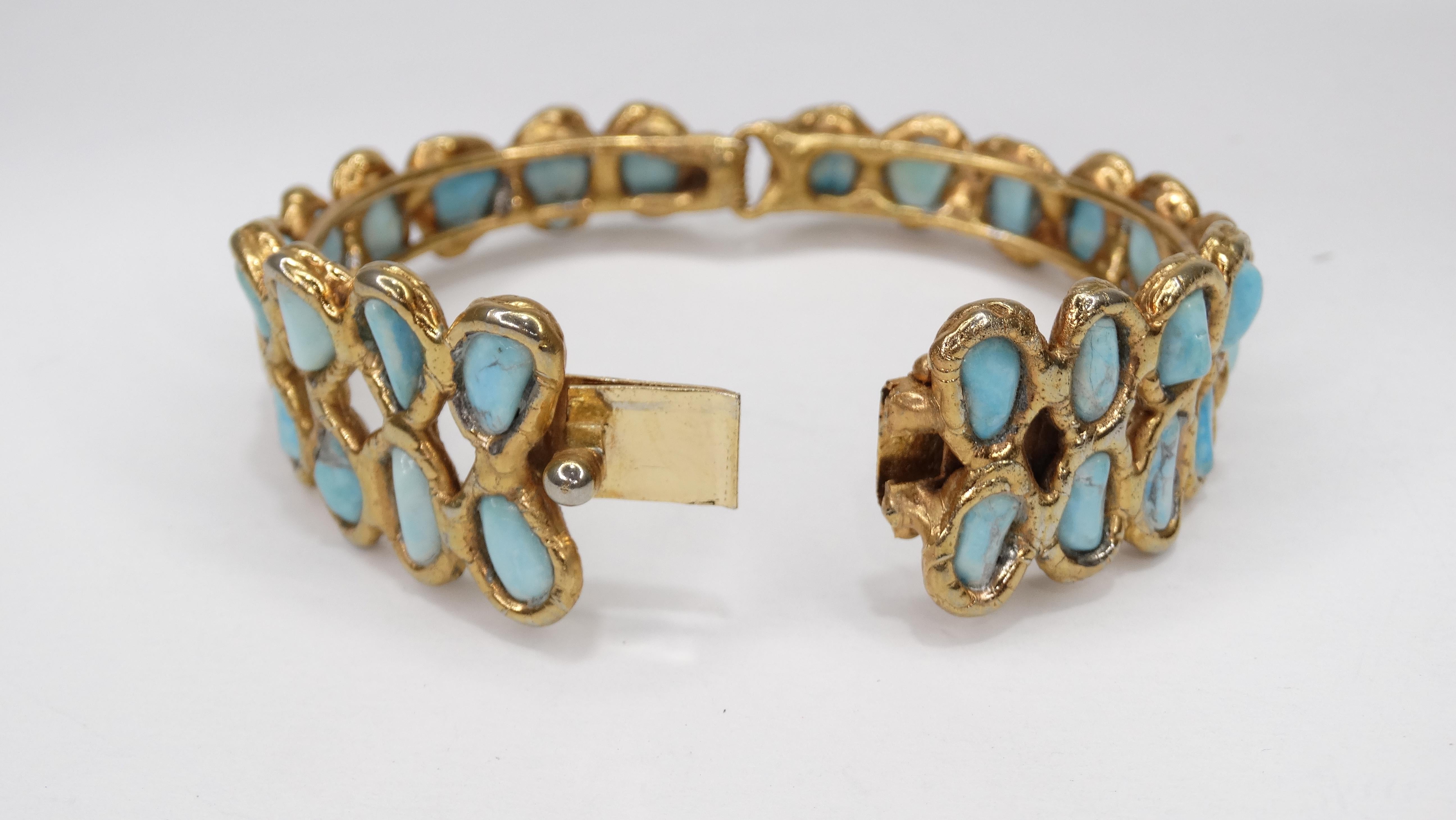 Add some color to your summer looks with this gorgeous cuff! Circa late 20th century, this cuff is crafted from sterling silver plated in gold and finished with two rows of rough-cut Turquoise. Box tab insert closure stamped 925. Unique and a true