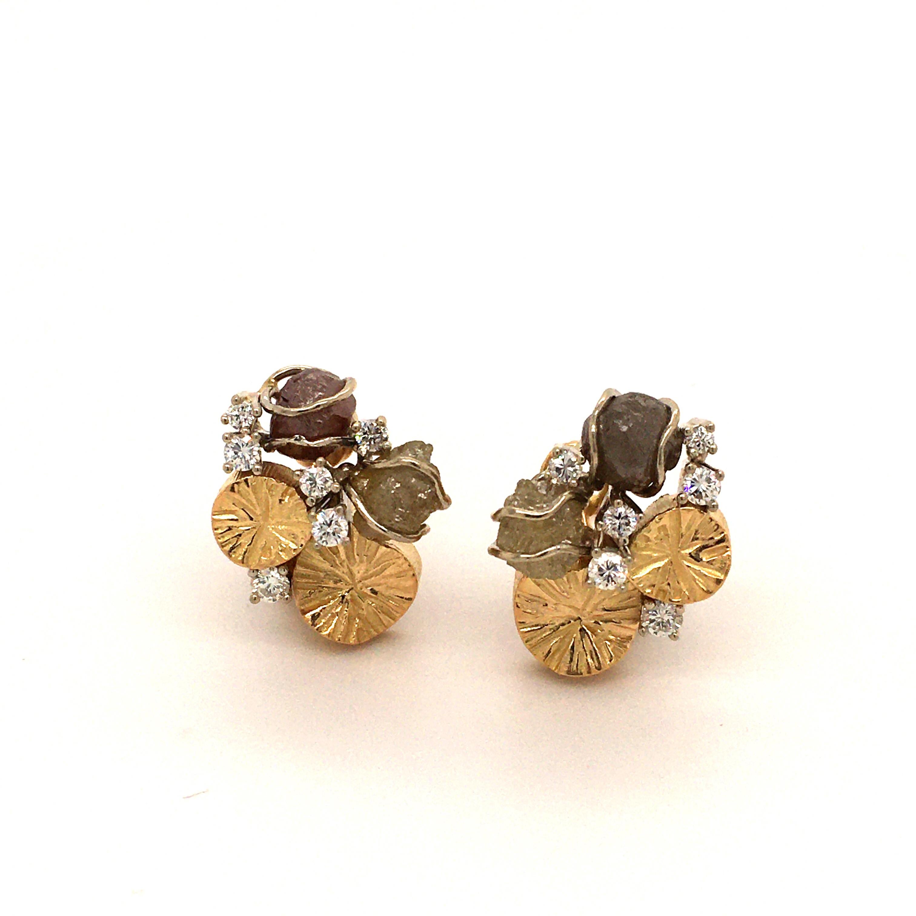 This pretty pair of ear clips is made of 18k white and yellow gold. They are set with 2 rough diamonds each, in a brownish and yellowish tone. The 12 brilliants are totalling 0.40 ct with H-vs quality. The decorative hand engraved gold elements