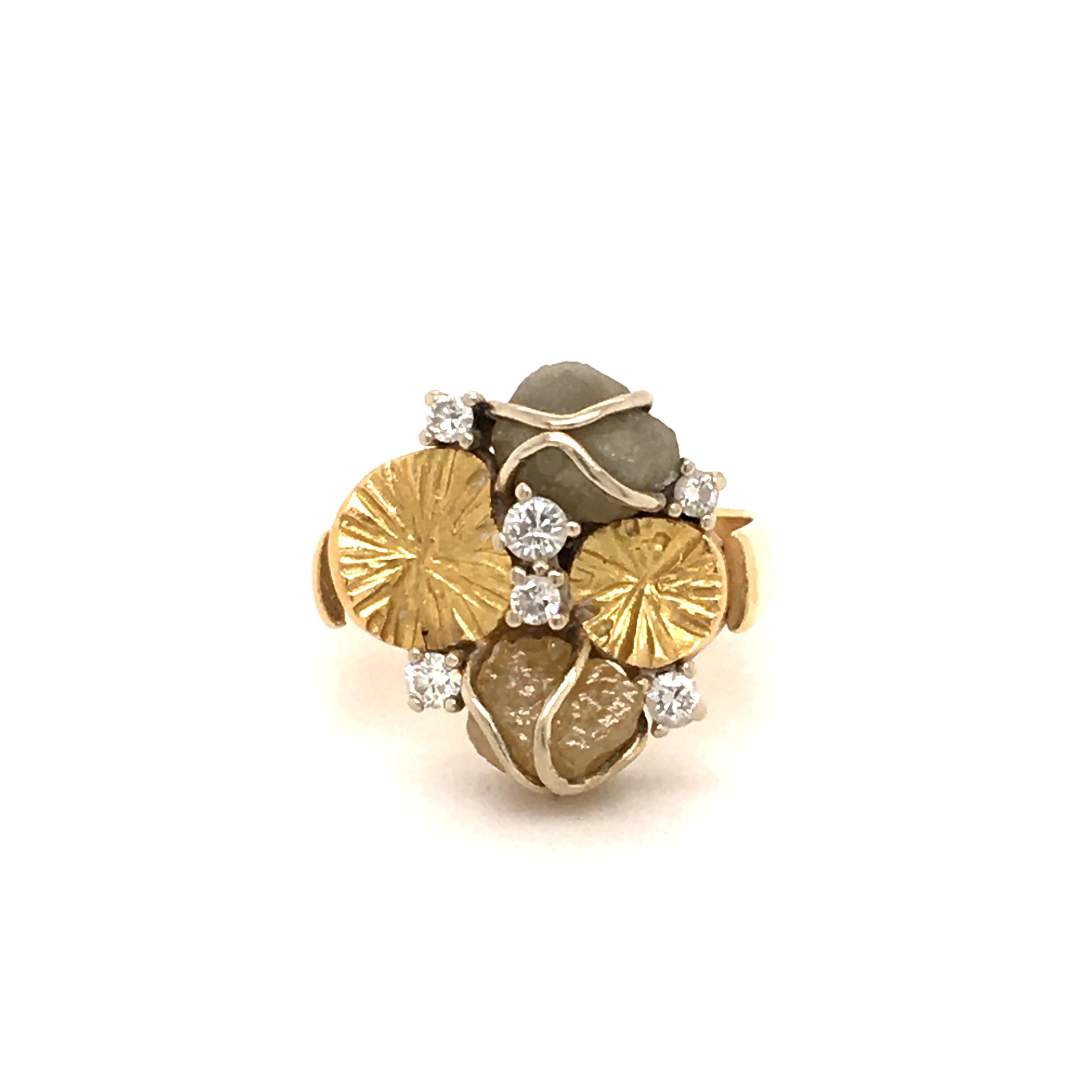 This pretty ring is made of 18k white and yellow gold. Set with 2 rough diamonds, in a grayish and yellowish tone. The 6 brilliants are totalling 0.20 ct with H-vs quality. The decorative hand engraved gold elements remind of water lily petals.

Btw