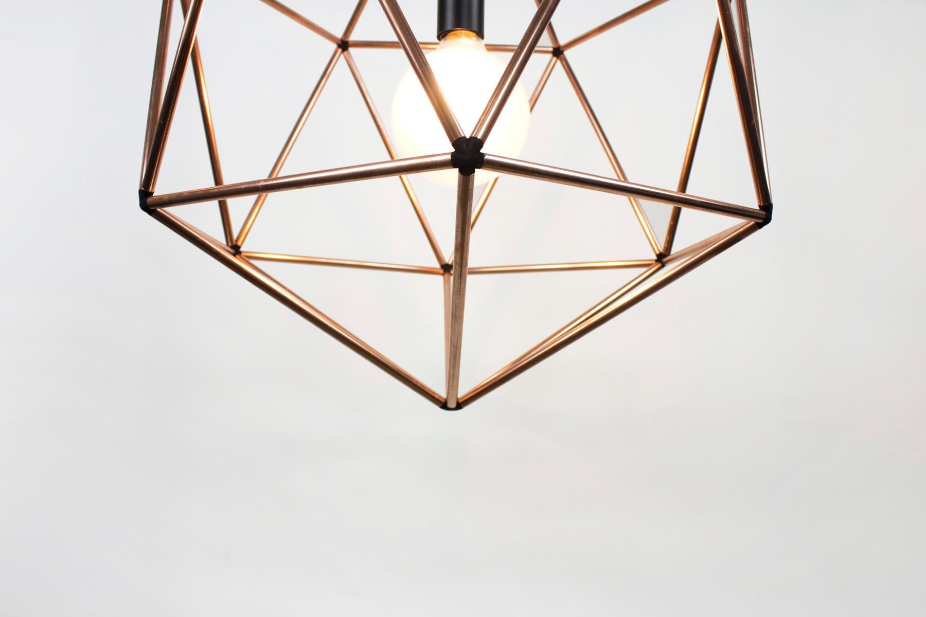Rough diamond pendant is a decorative fixture that combines handmade craftsmanship with digital technology. The design combines a 3D printed joining system with handcut and assembled copper or brass tube. The result is a decorative feature light