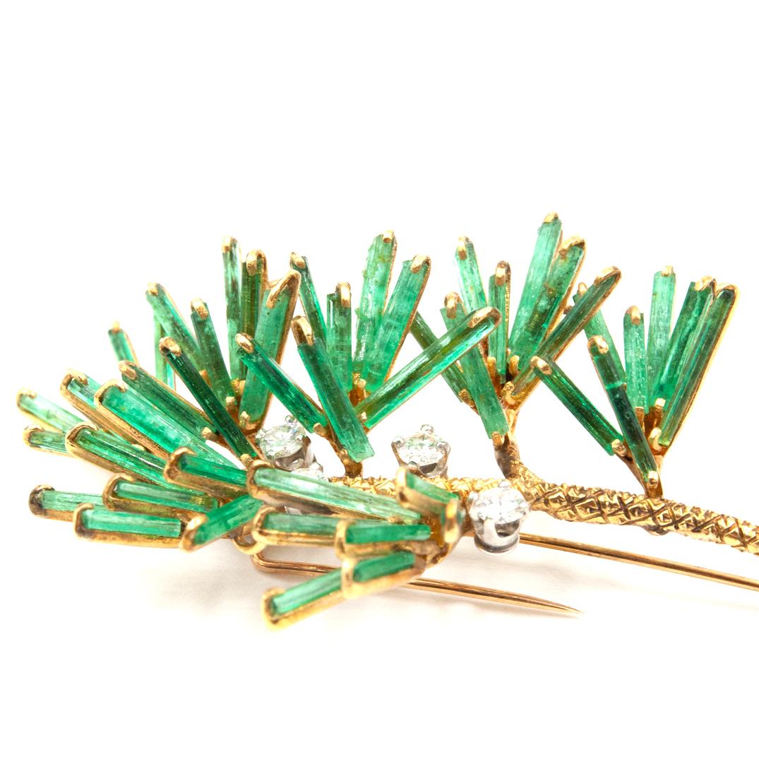 A 18K yellow gold, Emerald and Diamond brooch. The brooch is a true masterpiece with 49 natural rough Emerald stones set as branches, resembling leaves on a plant. Four natural round Diamonds approximately .90 Ct are set along the brooch giving this