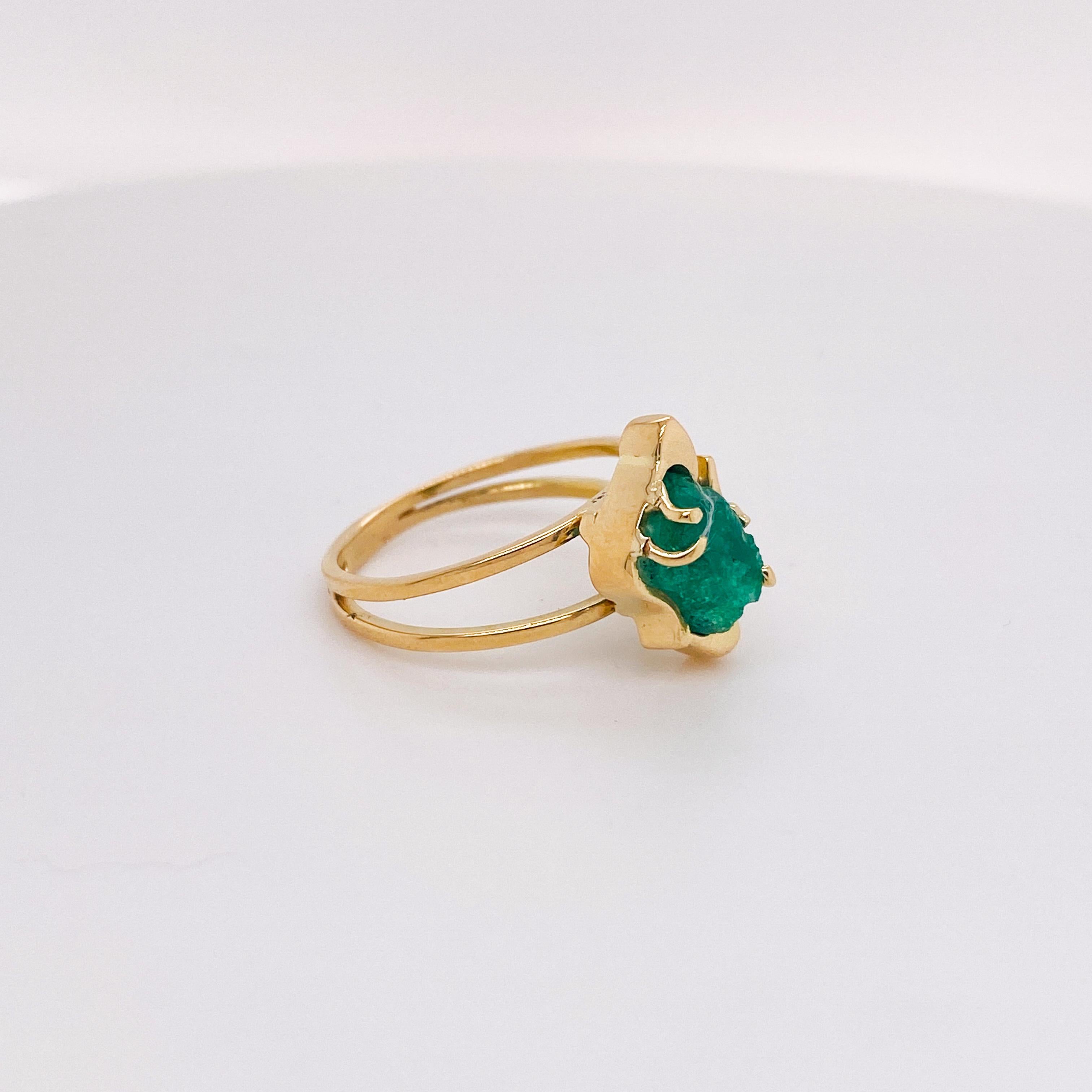 This unique emerald ring has a interesting green rough cut emerald. The band is split and there is an interesting wire design that holds the emerald in a creative way. The 14 karat yellow gold ring is very simple but so attractive. The ring can be