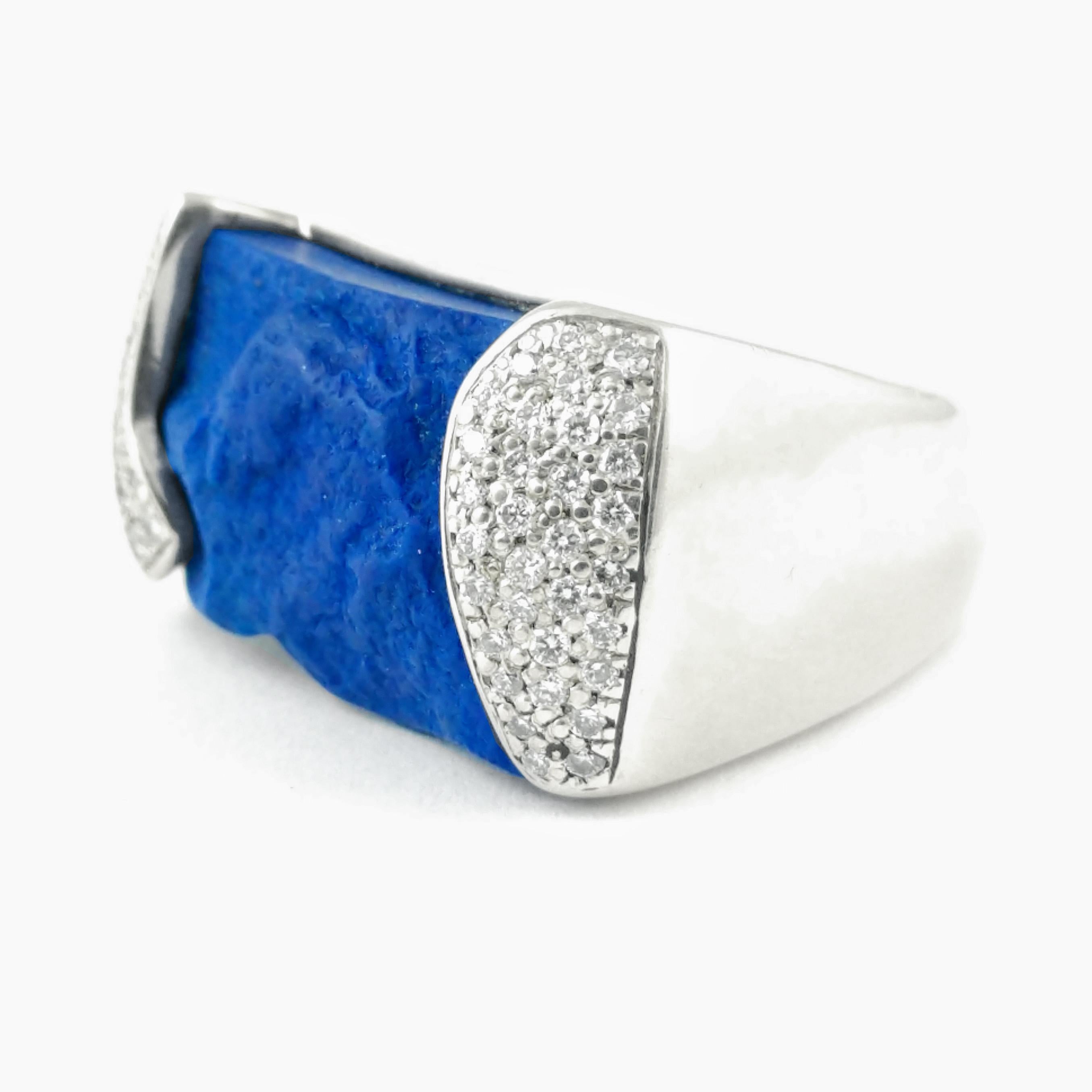 This Cornelis Hollander western inspired ring features a lapis gemstone that is left rough to give it a rugged but elegant look. The lapis weighs 18.46 ct., accented with .36 ct. of G VS2 diamonds pave set on the sides of the ring's top. The finger