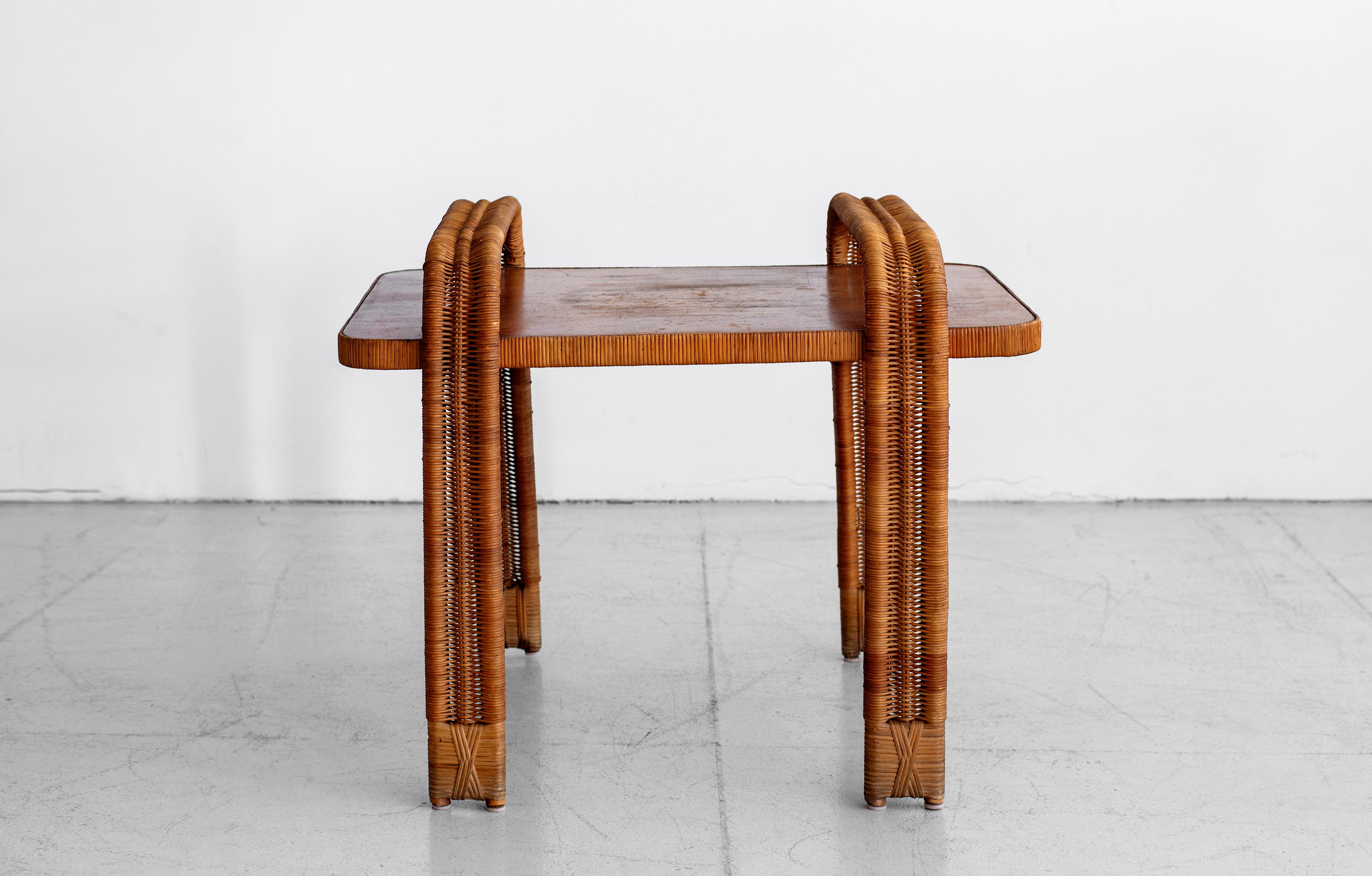 Fantastic French side table attributed to Edition Rougier. Laminate wood top with curved arched wicker legs and rattan wrapped feet.