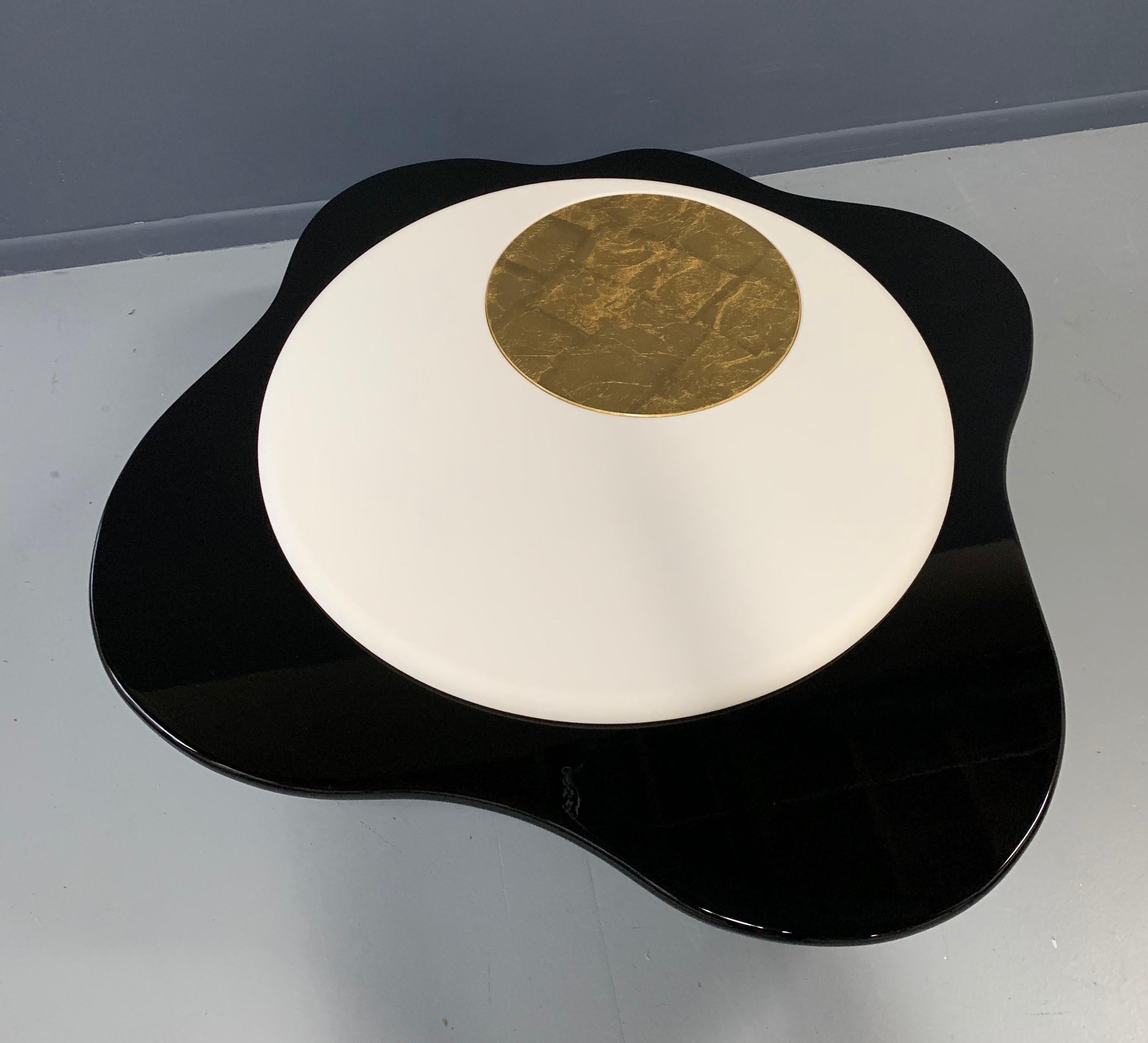 This amazingly shaped coffee table in gold leaf, leather, and smooth black lacquer will be an immediate show stopper in any room you choose to put it in.