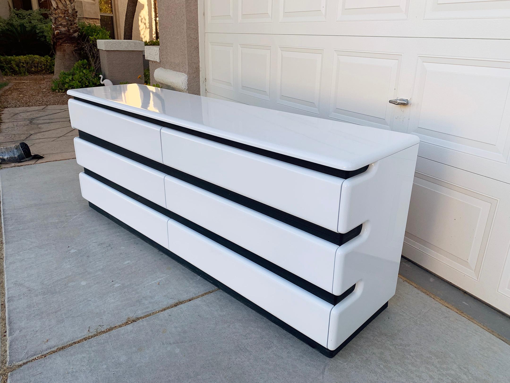 An absolutely stunning Postmodern dresser by Rougier. This dresser has clean white gloss with black accents and would look perfect in any modern, Mid-Century Modern, Space Age or Memphis style environment.

This dresser is in near perfect