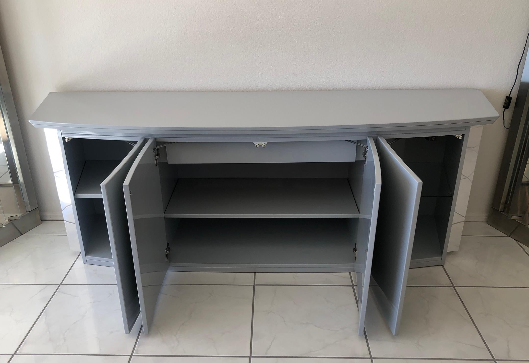 An absolutely stunning credenza or buffet designed by Rougier. This grey, high gloss credenza features exaggerated chrome accents and is in near perfect condition with very minimal wear.

This Post modern credenza has a very Karl Springer style