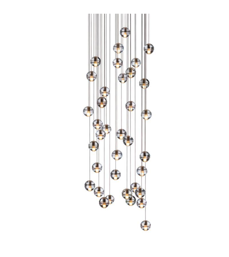 Round 14.36 chandelier lamp by Bocci
Dimensions: Diameter 75.5 x H 300 cm 
Materials: Brushed Nickel, Cast glass, blown borosilicate glass, braided metal coaxial cable, electrical components, white powder-coated canopy.
Available in Square, or