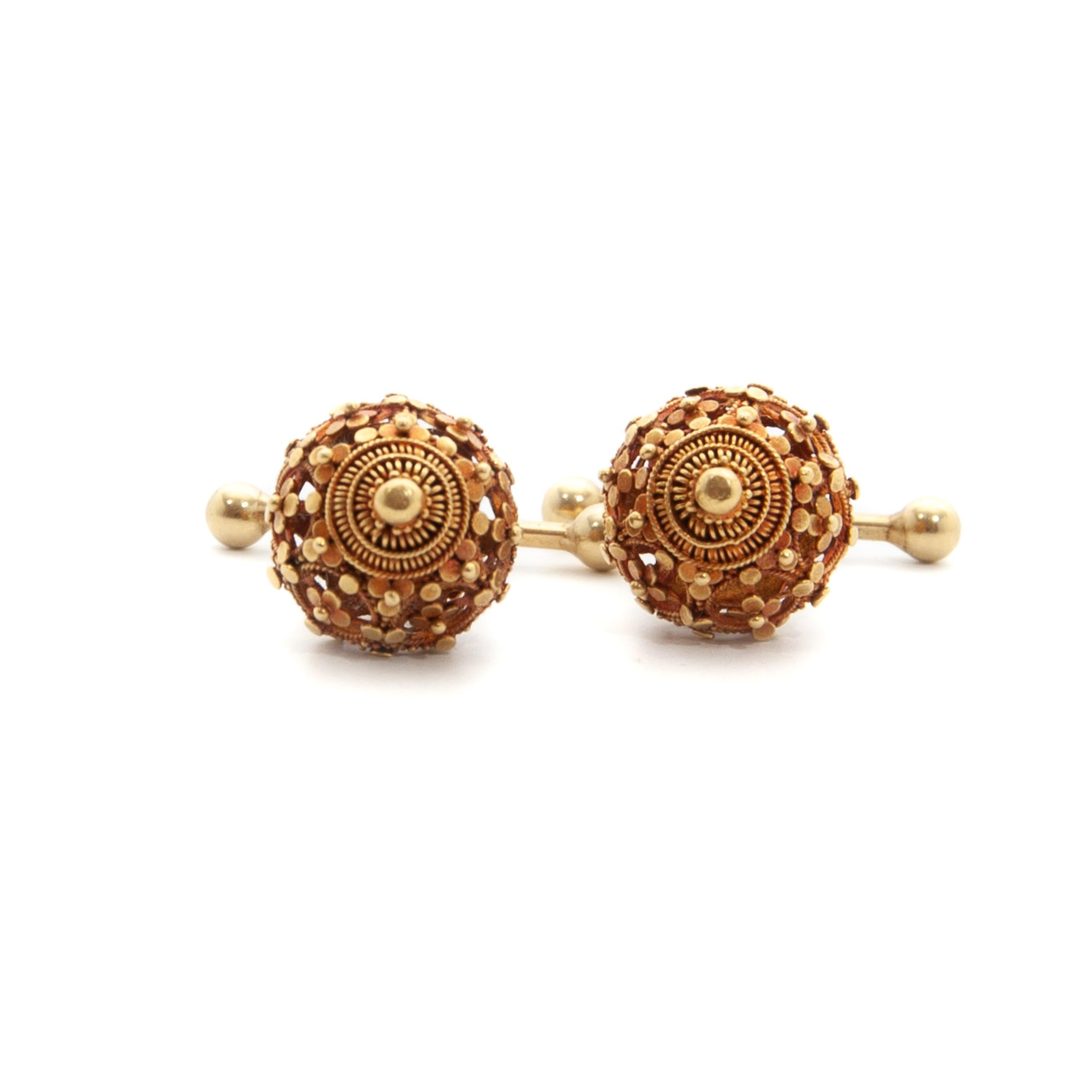 A magnificent pair of 14 karat gold cannetille and filigree round openwork cufflinks. These early 20th century gold cufflinks have a beautiful design with an openwork structure, decorated with gold flowers and fine granulation. At the top of the
