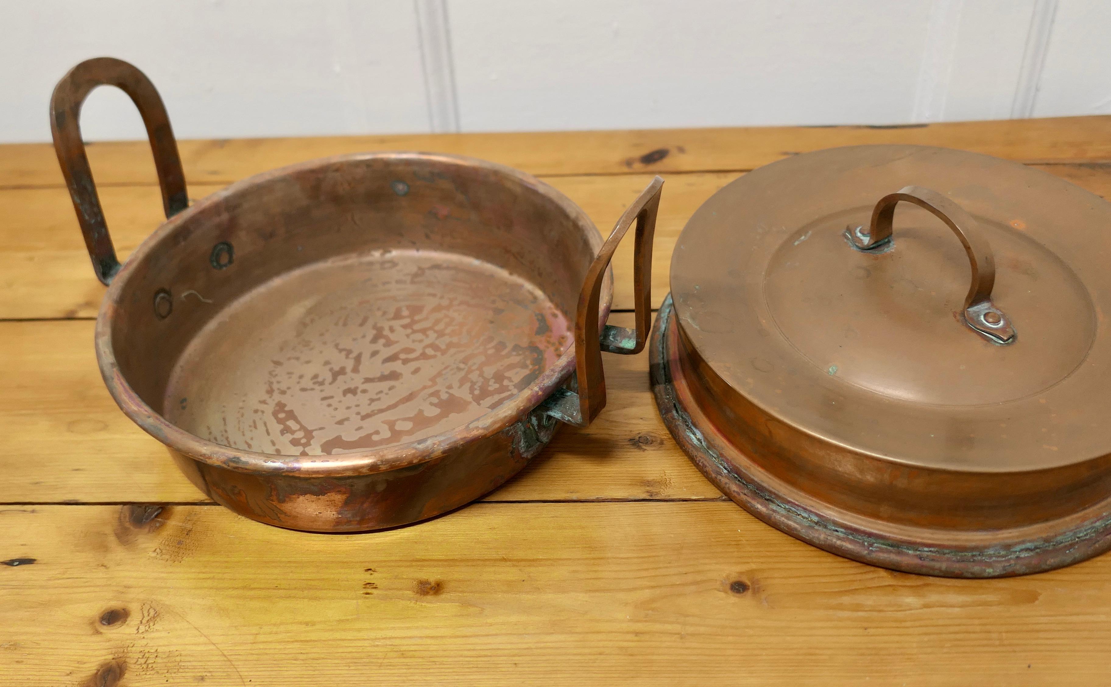 Round 19th Century Copper Steaming or Warming Pan with Lid 

This is a lovely looking 19th Century Pot it has a wide rim so that it can be suspended over water instead of being placed directly on the heat. 
The pan has long handles and a well