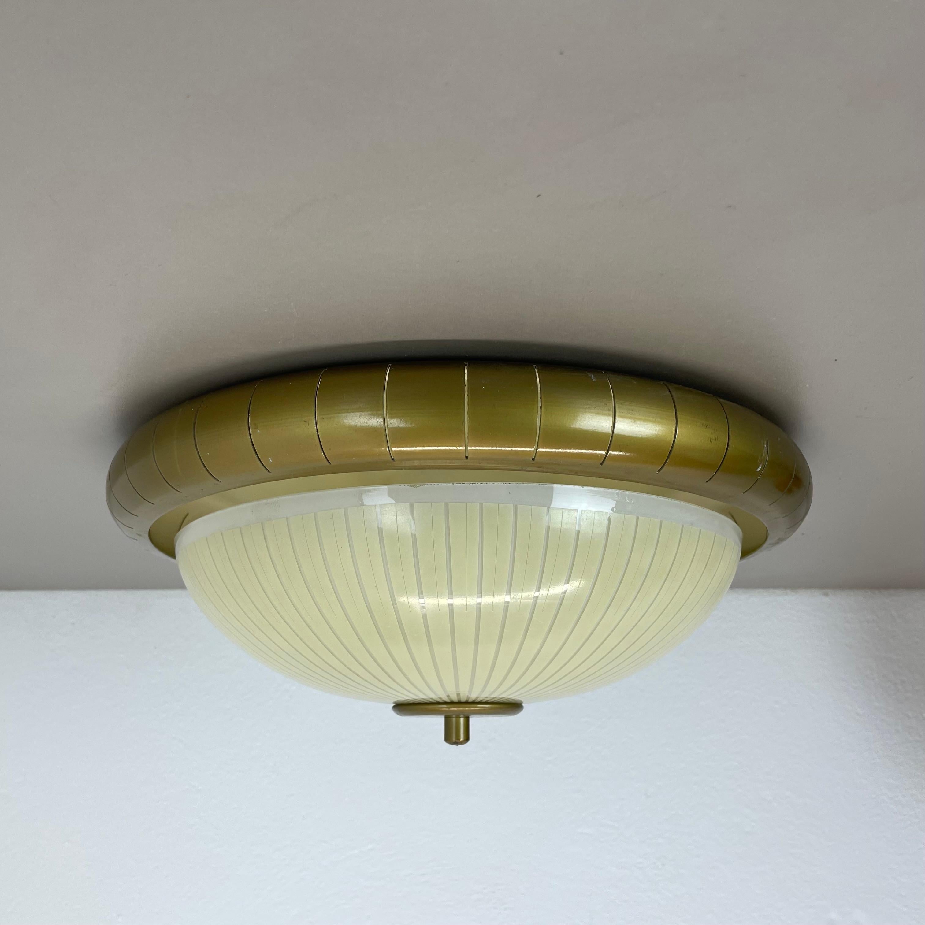 Article:

ceiling light, uplight flush mount also useable as wall light



Origin:

Italy



Age:

1950s



This vintage modernist light was produced in the 1950s in Italy. The lights is made of metal in a gold tone finish with a 36cm round back