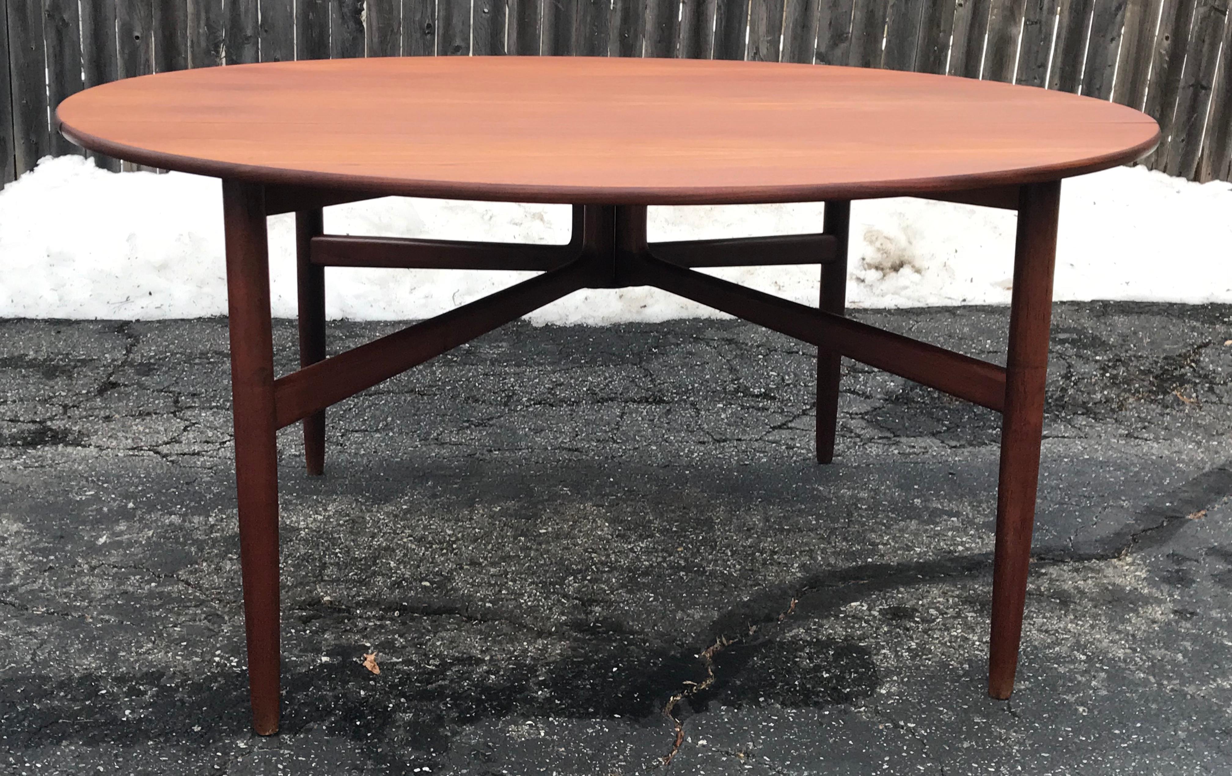 Beautiful solid teak drop-leaf round dining table. Hans Wegner style, well executed base design with piano hinge drop leafs, opens to 60