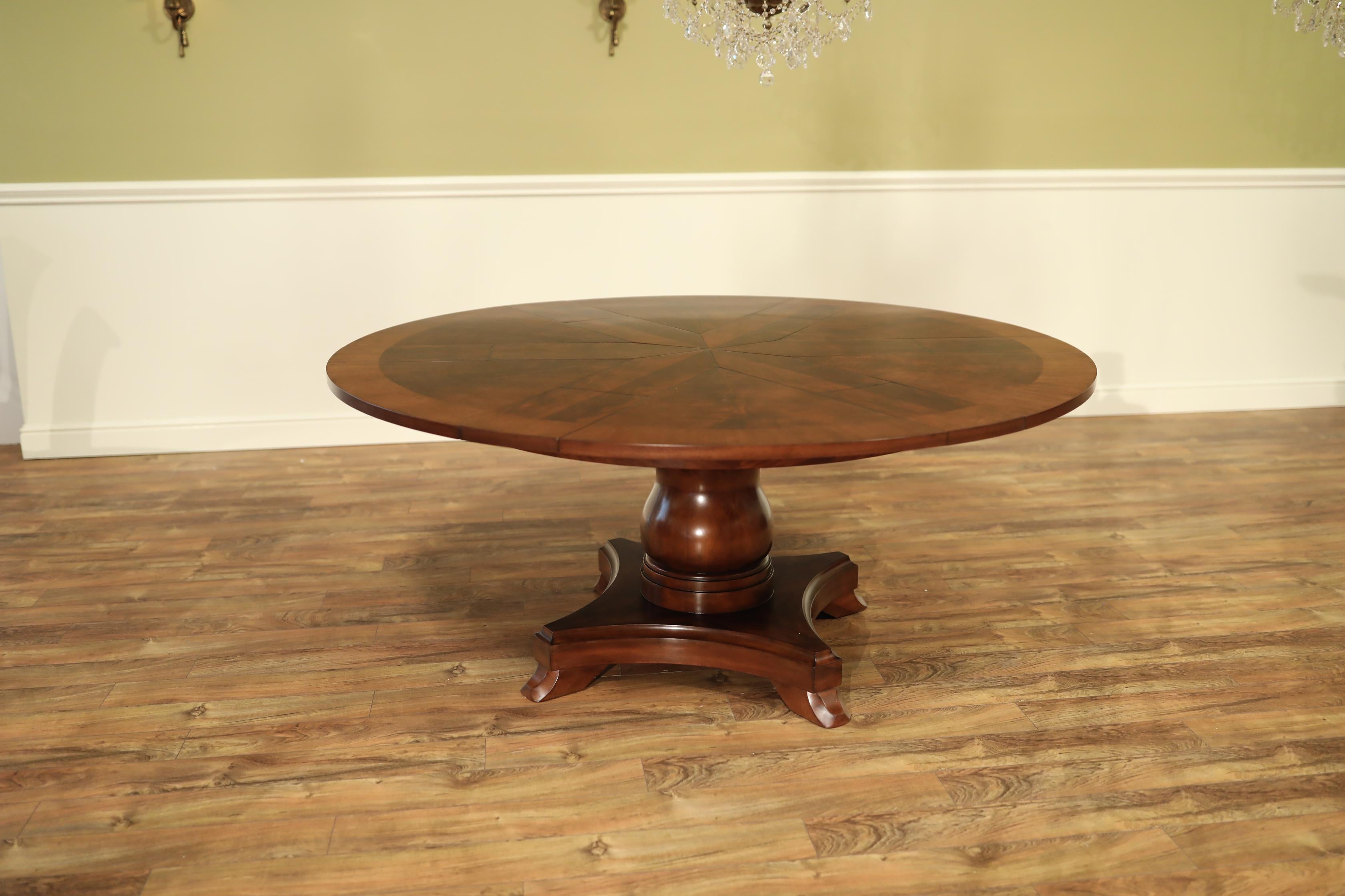 This is round Jupe style traditional mahogany dining table by Leighton Hall. It is one of our new prototype designs. It features a radial cut field of West African swirly crotch mahogany and a border of satinwood. The Jupe design allows the leaves