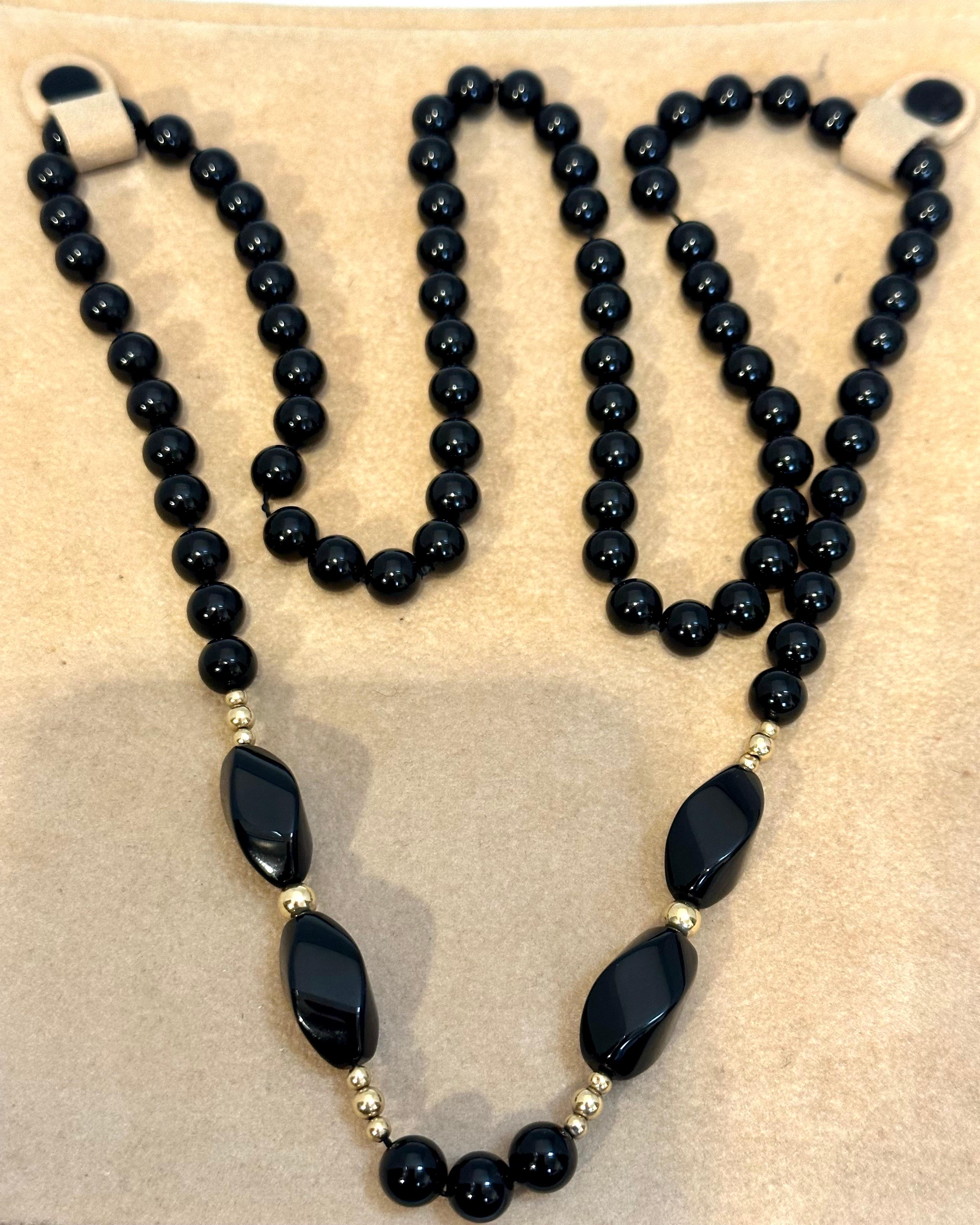 Round 8 MM Bead Black Onyx & 14 Karat Gold Bead Necklace 32 Inch Long
Beautiful , Very Dressy but also good for casual dressing 
Black 8 MM bead necklace which has  14 Karat yellow gold beads too
The necklace also features 4 very large long beads to