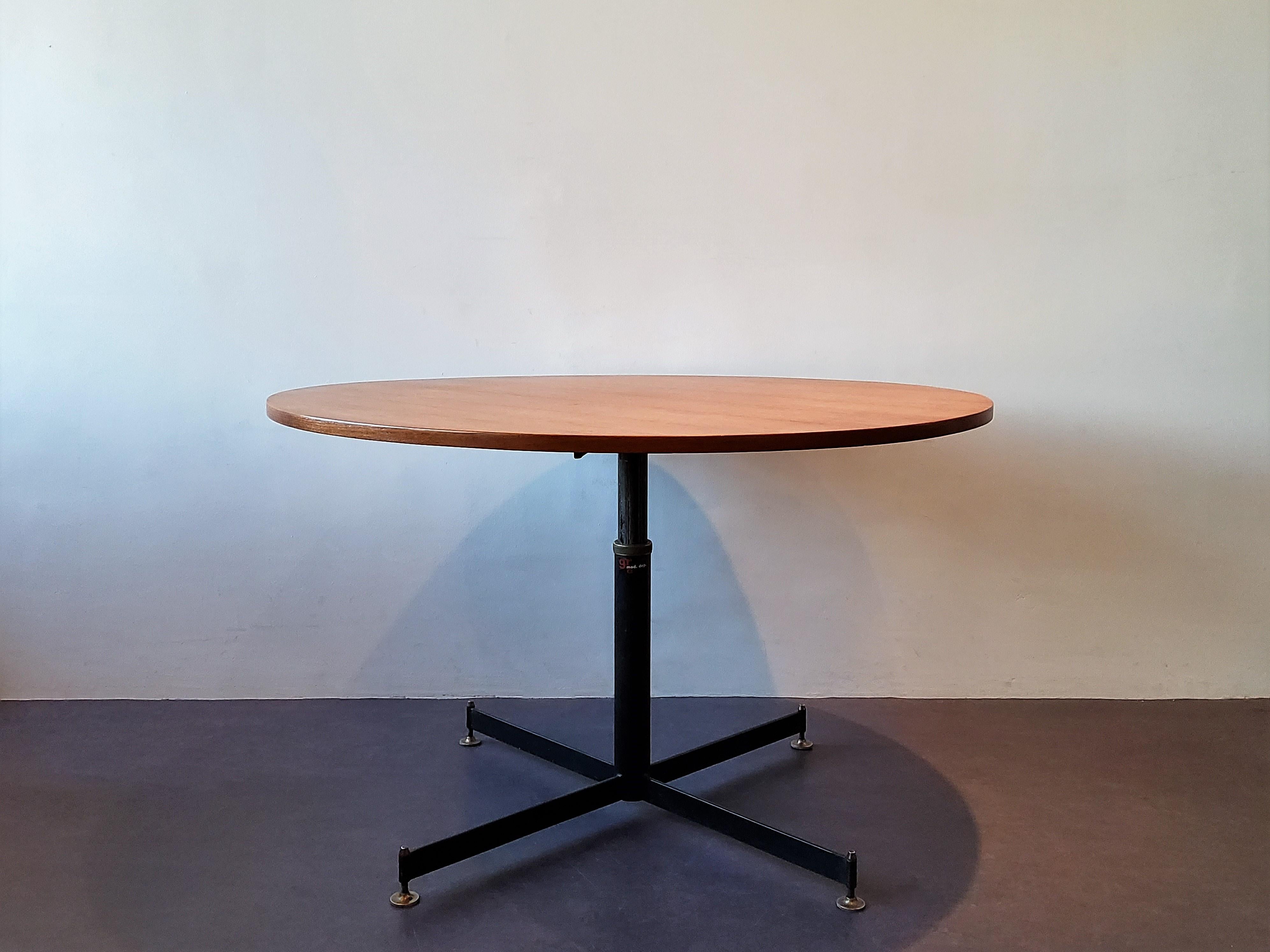 This stunning table is of Italian design and looks very much like the designs of Ignazio Gardella. It has a teak veneer wooden round top and adjustable base (by turning the knob) that extends in height for use as either a coffee or a dining table.