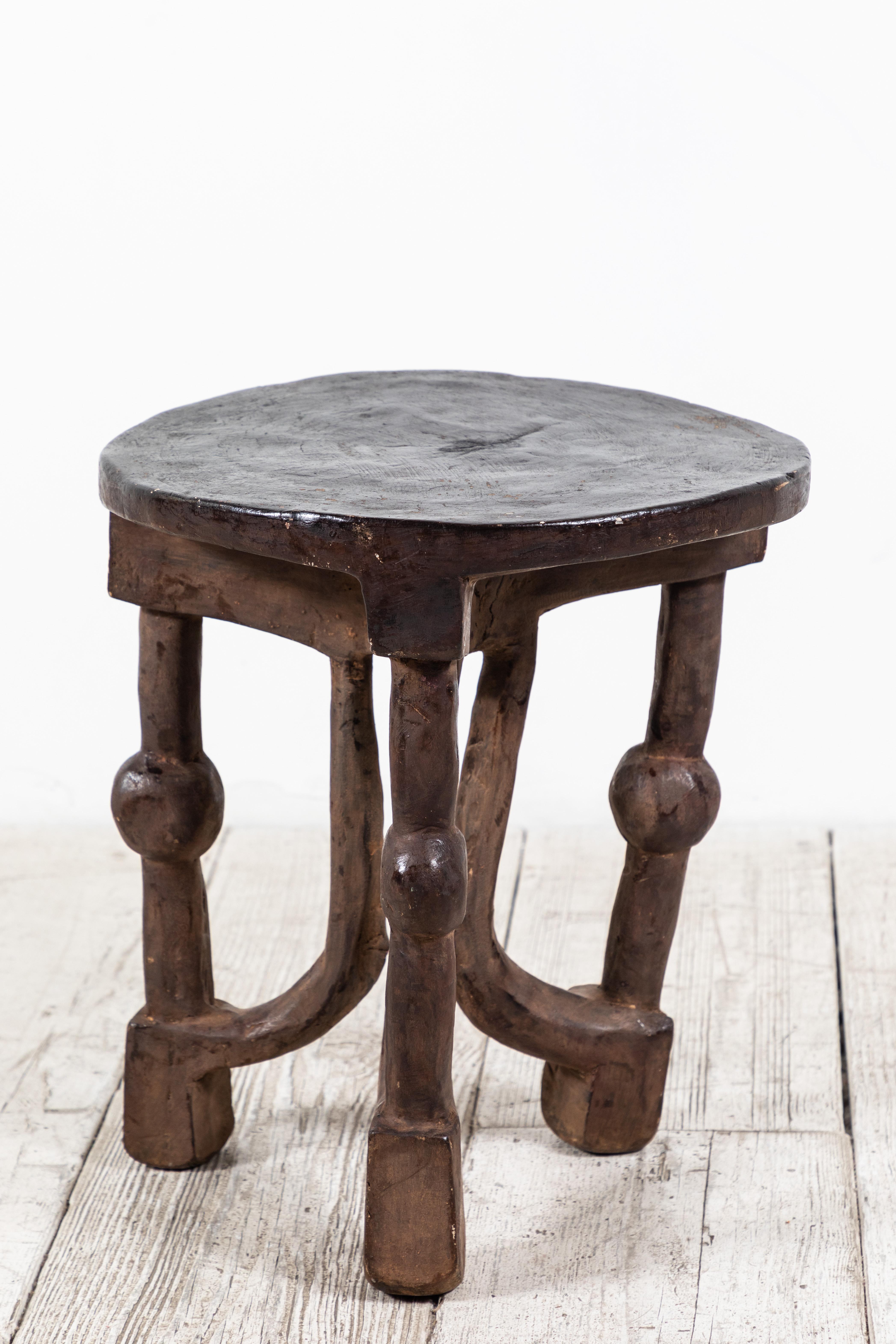 Solid round African stool with unique carvings.