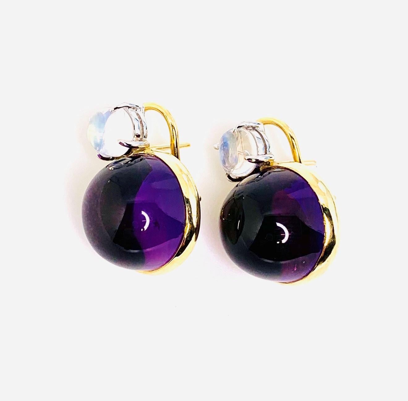 Giant amethyst cabochons set with glorious moonstones are featured in these 18k yellow gold French clip drop earrings. The amethysts are the color and size of luscious Concord grapes with their perfect outline set flawlessly in rich gold bezels. The