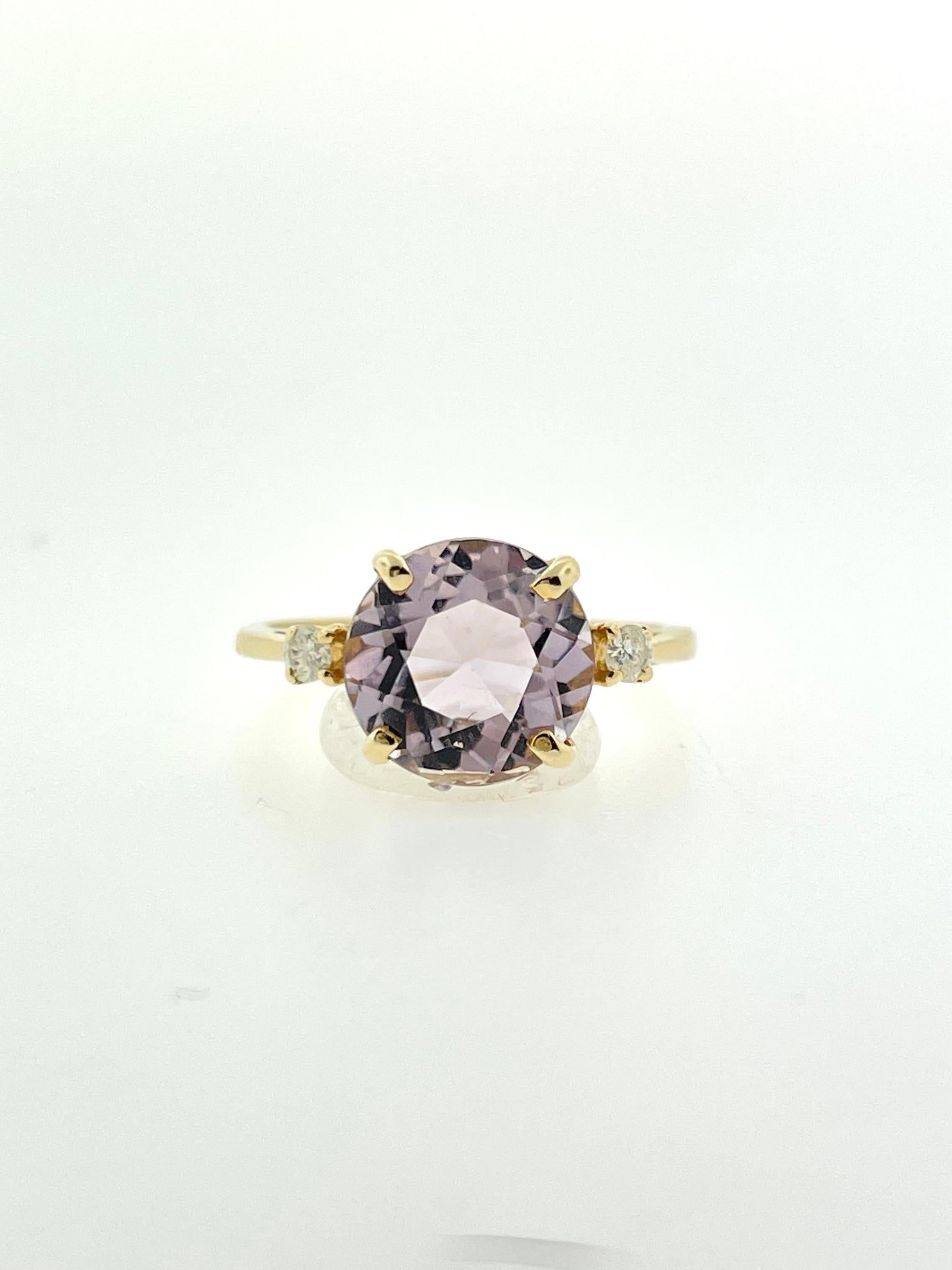 A light-colored round amethyst with two adorning round bright diamonds all set in yellow gold, a beautiful piece for anyone! 