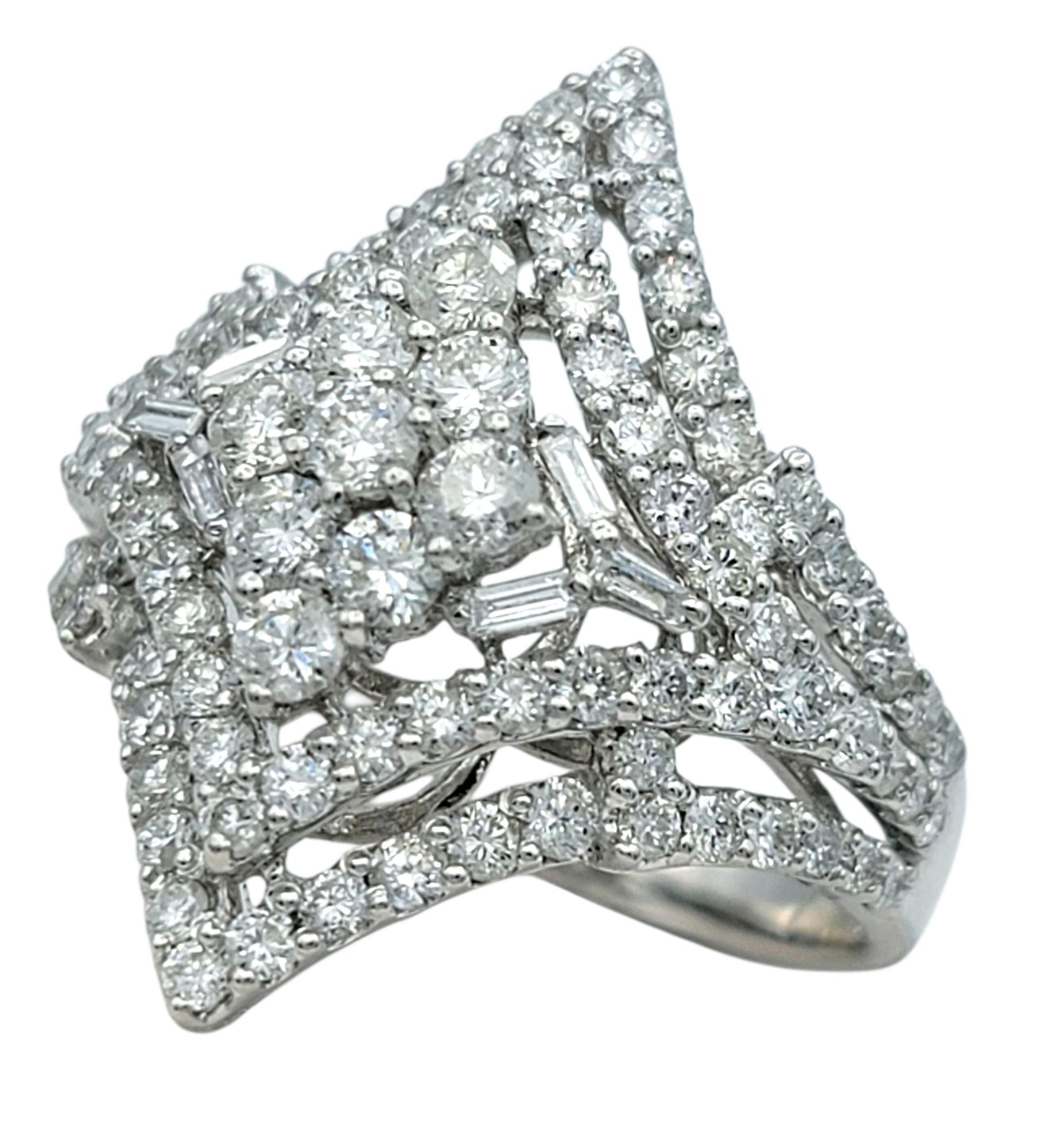 Ringgröße: 7

Dieser Diamantring besticht durch sein kühnes, geometrisches Design, das sich um einen einzigartigen, diamantförmigen Cluster gruppiert. Die Kombination von Diamanten im Baguette- und Rundschliff schafft eine mosaikartige Oberfläche