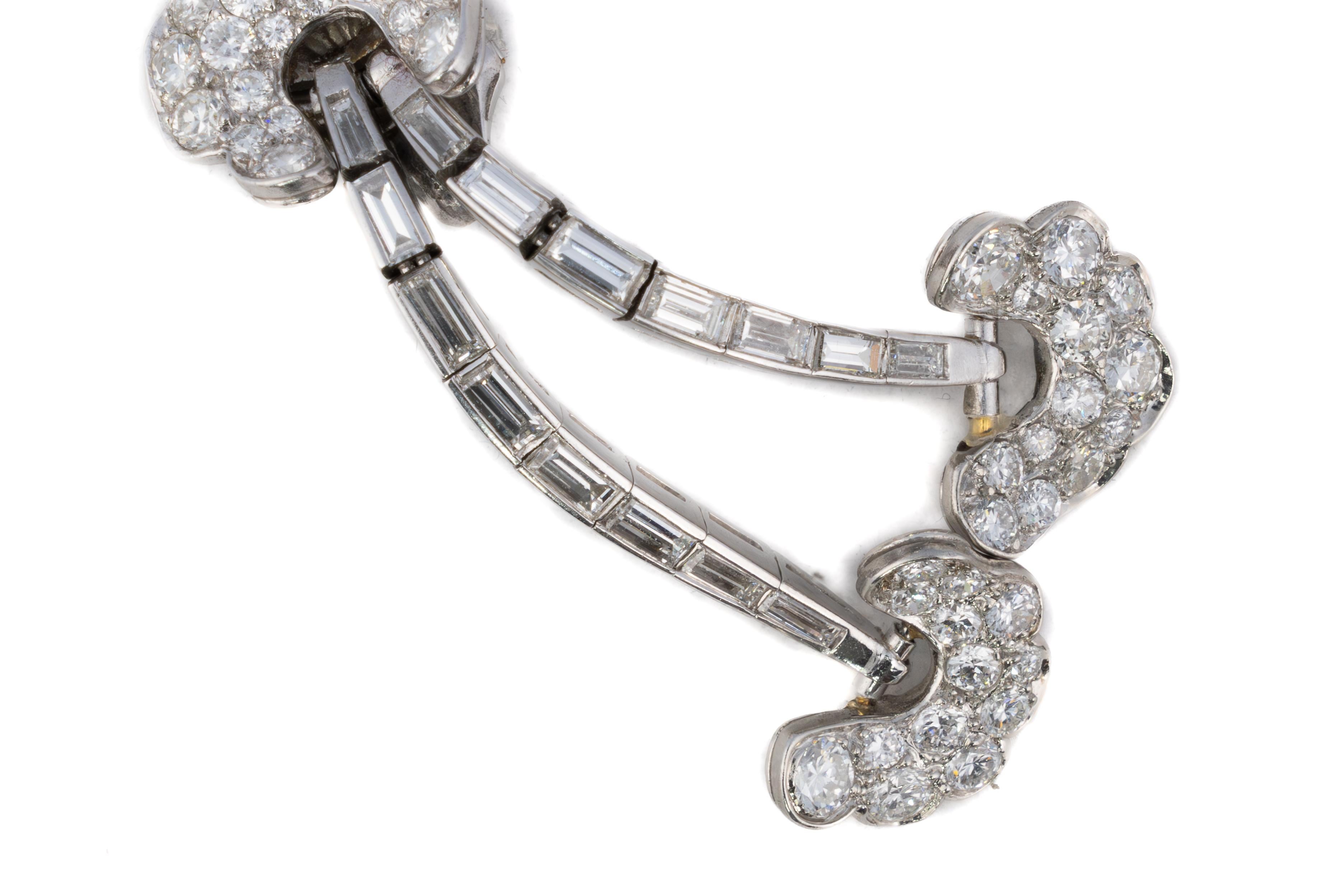 Runde und Baguette-Diamant-Ohrringe mit doppelter Tropfenform

Beschreibung:
Ein elegantes Paar Vintage-Ohrringe mit einem verspielten Doppeltropfen-Design mit geschwungenen Baguette-Diamantarmen, die in wolkenartigen Büscheln aus runden Brillanten