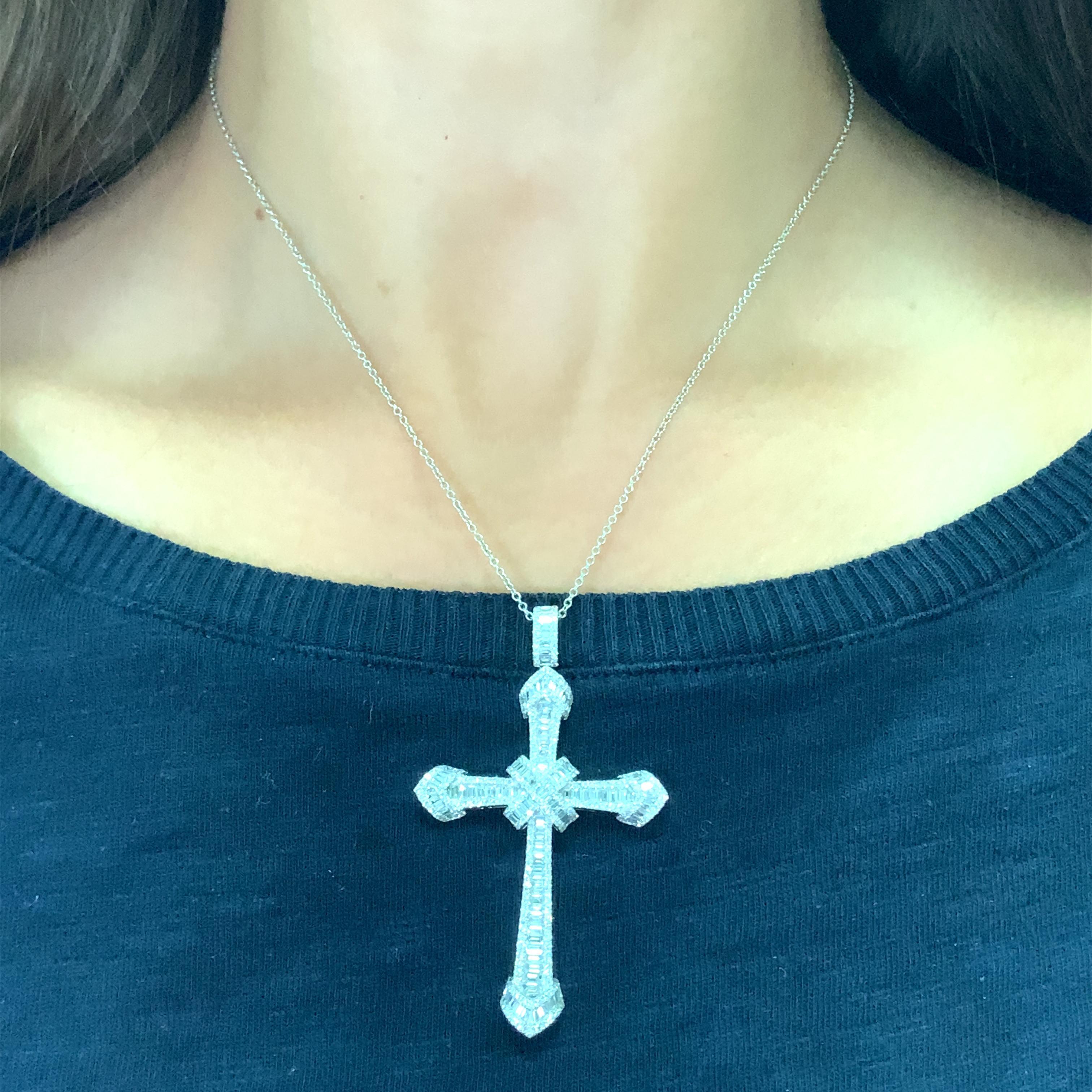 Eleva la tua collezione di gioielli con questa splendida collana con ciondolo a croce in oro bianco 18k con un brillante diamante rotondo da 3,00ct e squisite pietre a taglio baguette. Il ciondolo a tema artistico è incastonato in un castone e