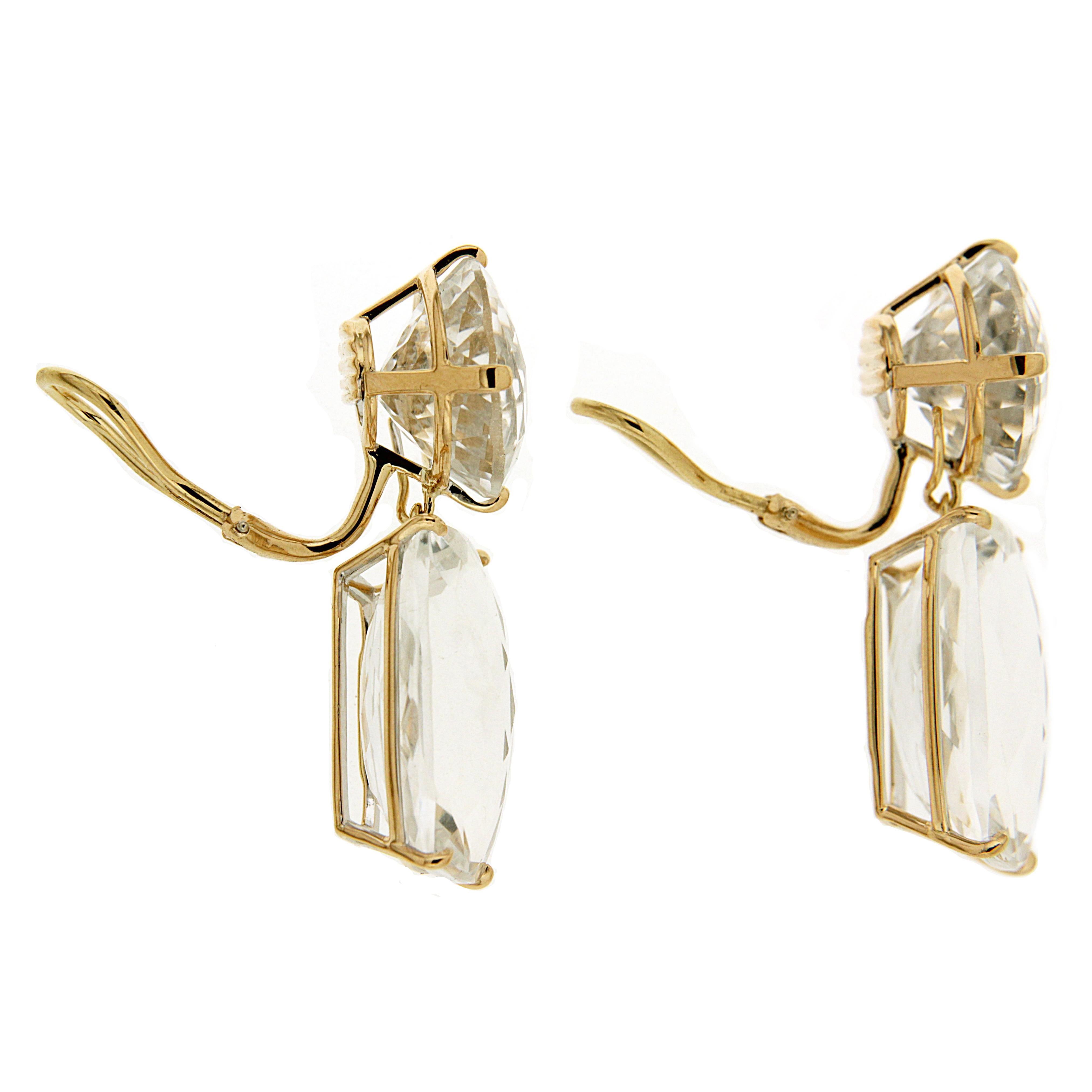 White topaz shine in these drop earrings. Round cut topaz decorate the tops, while elongated cushion cuts hang below. Minimal 18k yellow gold prongs secure the jewels while remaining a background detail. These earrings are finished with clip-backs. 