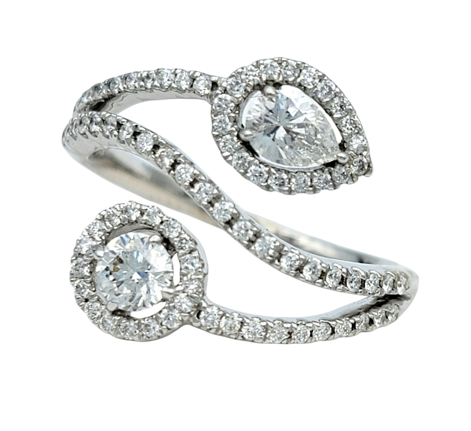 Misura dell'anello: 9 

Concediti una moderna raffinatezza con questo squisito anello bypass con pavé di diamanti. Questo splendido pezzo presenta un design splendidamente bilanciato con un diamante rotondo su un'estremità e un diamante a forma di