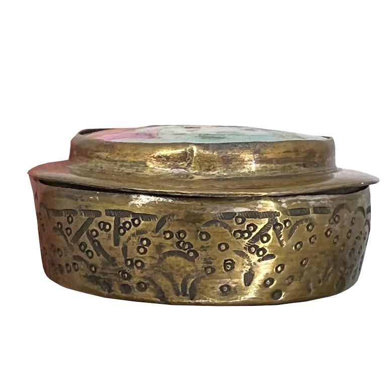A small brass snuff box or pill box with a hand-painted Rubaiyat scene. This small box will be great in a purse or even on a side table or coffee table. It is petite and round and features a tiny hand-painted Mughal or perhaps Moorish scene on a cut