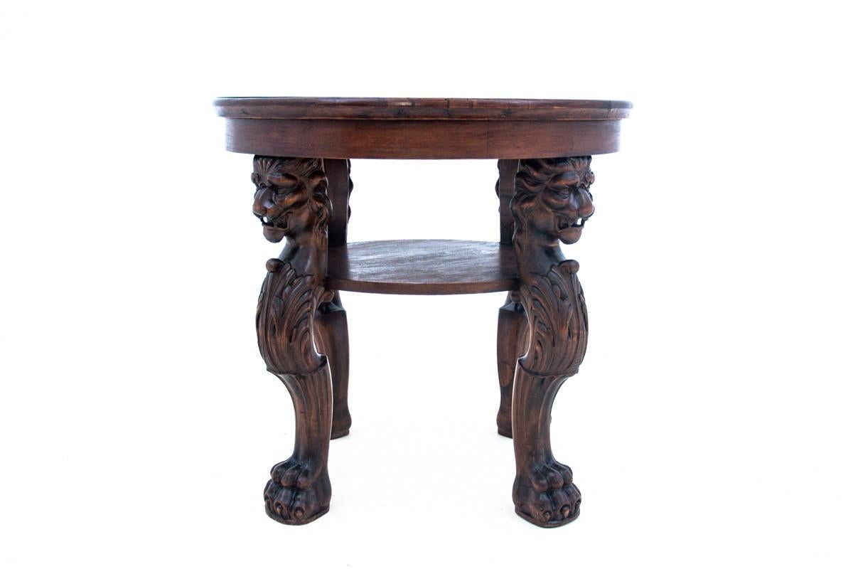 A historic table from the turn of the 19th and 20th centuries.
Legs carved in lion's motif. 
Excellent condition. 
Dimensions: height 63 cm / diameter. 66 cm.