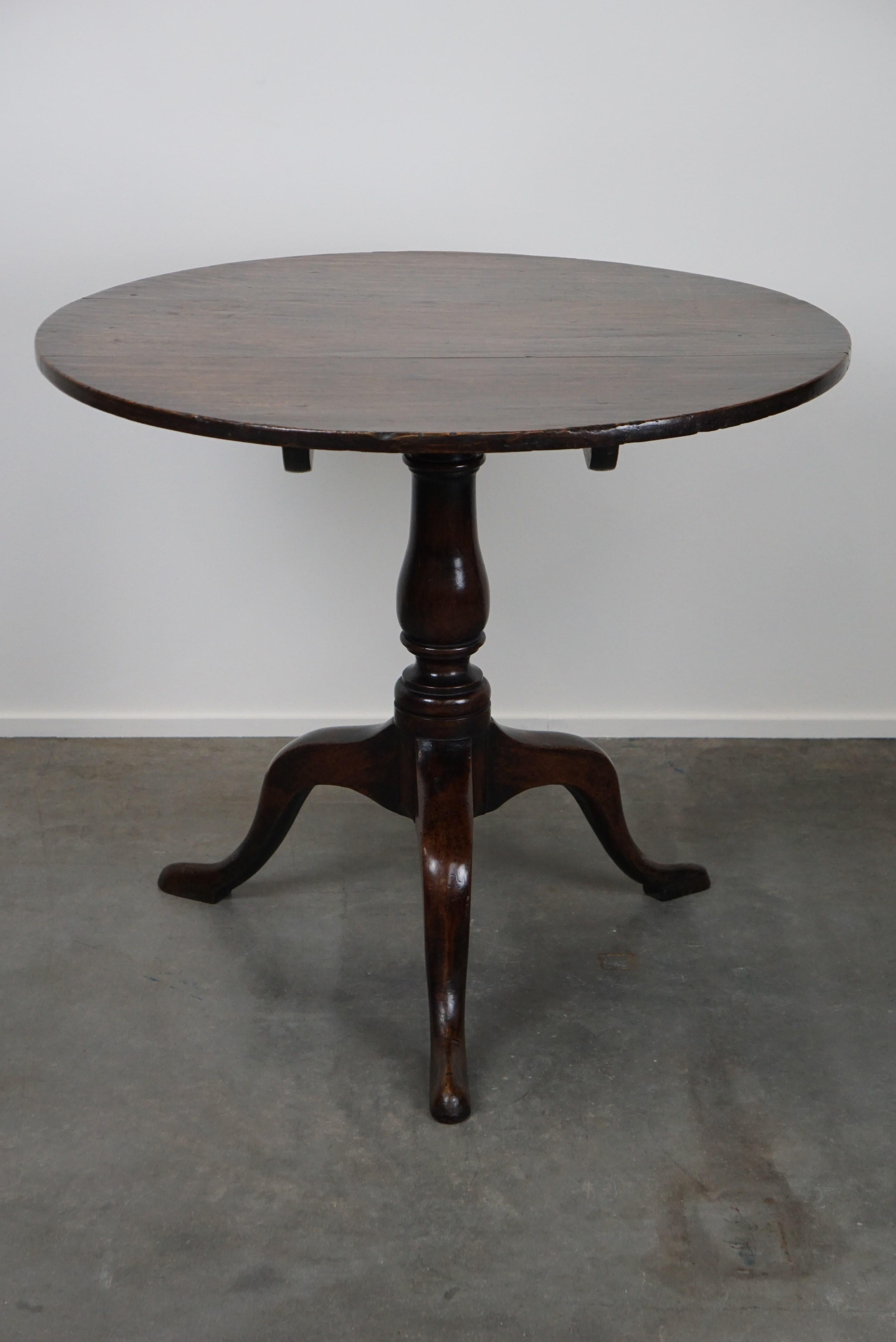 Offered is this beautiful round antique English oak tilt-top table with wonderful colors. This lovely mid-19th century English oak tilt-top table is in a very good condition and will look great in both a modern and a classic interior.

Please