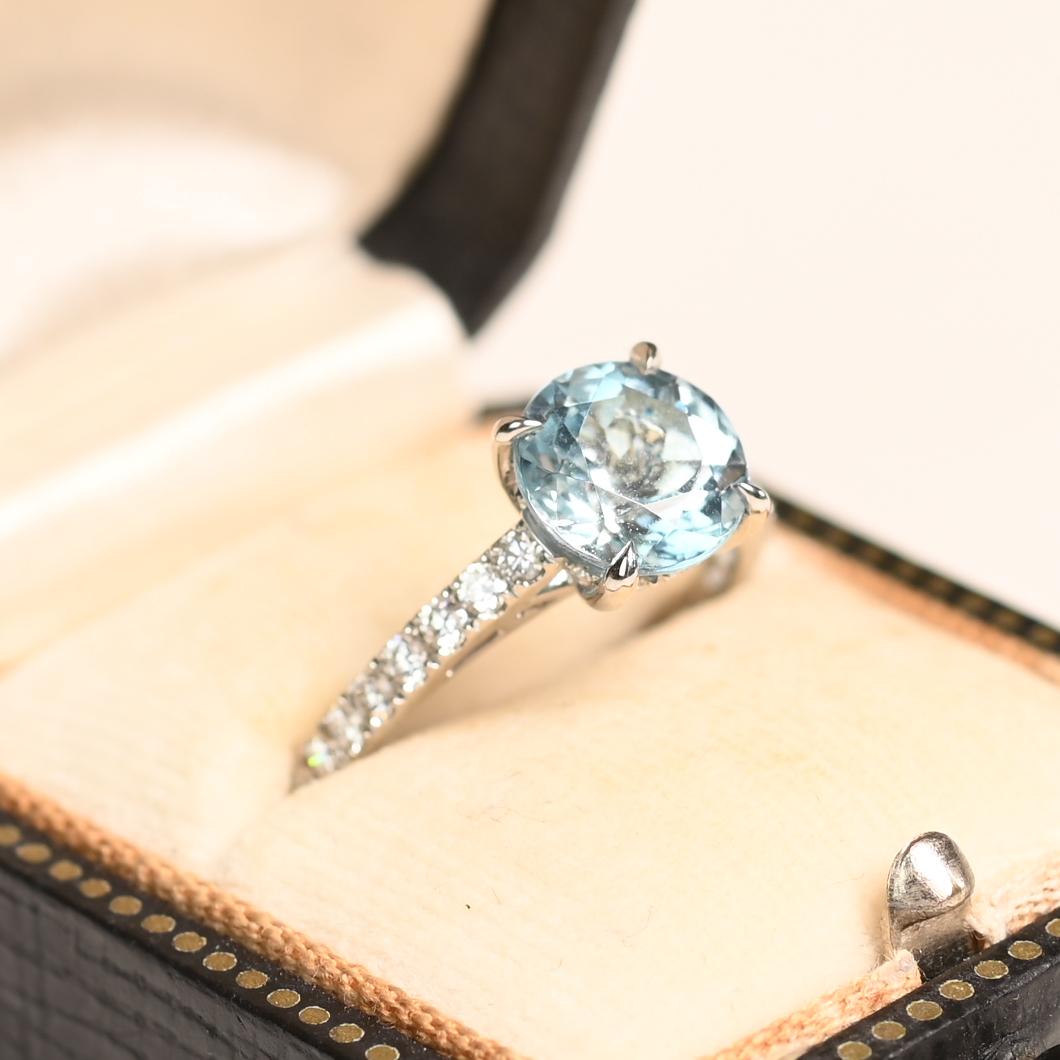 Cette exquise bague solitaire en platine met en valeur une captivante aigue-marine ronde d'environ 1,80 carat, solidement sertie dans une monture classique à griffes. La teinte bleu océan serein de l'aigue-marine est à la fois saisissante et