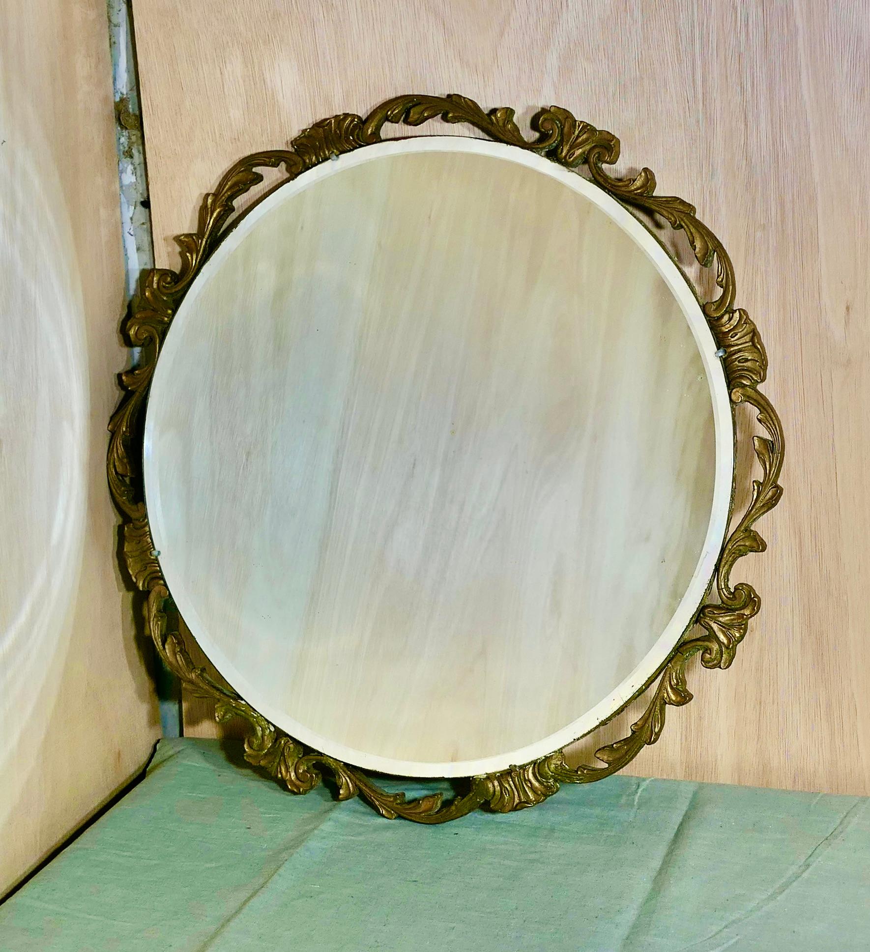 Miroir mural rond Art Déco Atsonea orné de dorures

Le miroir est rond, il a un cadre décoratif Art déco Rococo doré avec des  un miroir en verre biseauté au centre
Le verre du miroir est d'origine et en bon état, sans rousseur. 
Le miroir a un