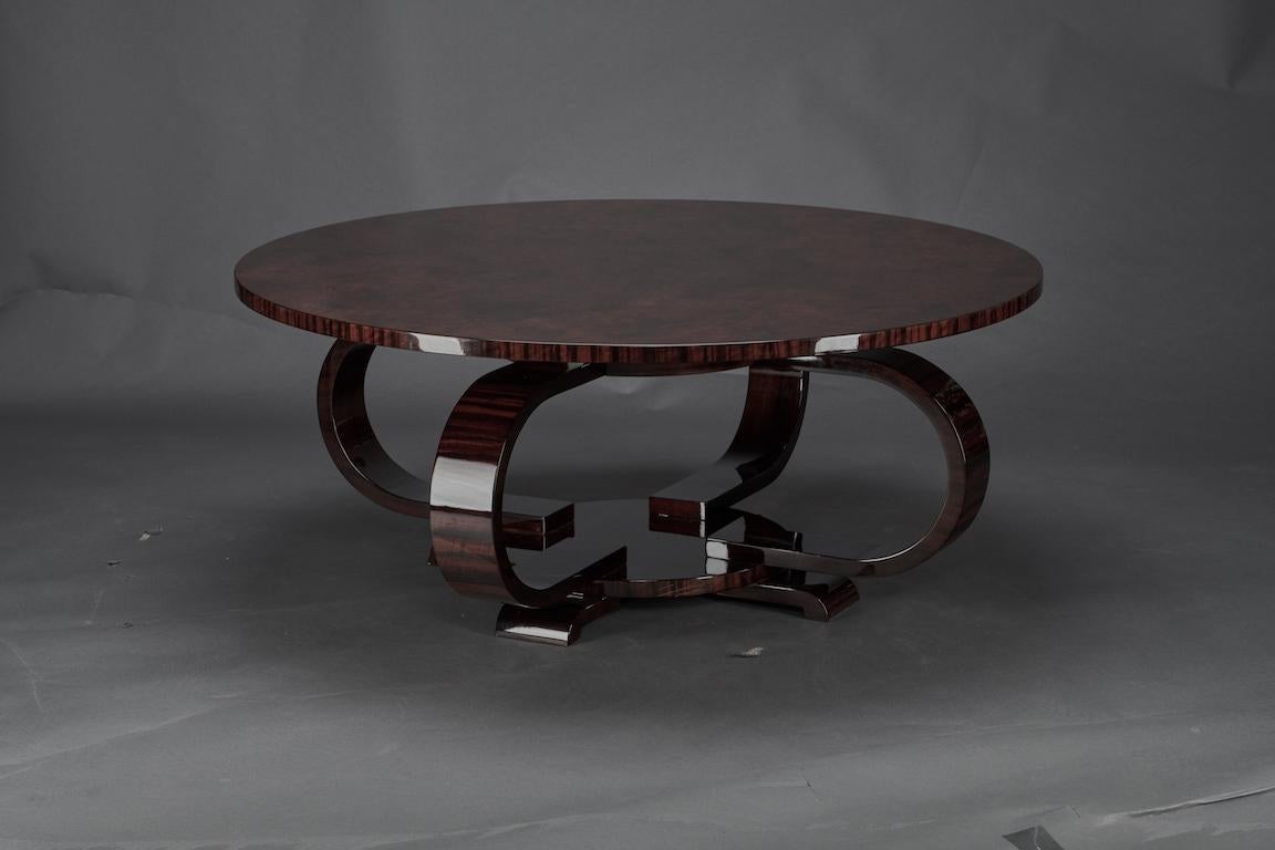 Coffee table has a round highly polished table top. it is attached to the base with 4 curved wooden elements. The base has 4 small rectangular legs that elevates the table from the floor.

 Condition is perfect. 

France, circa 1930s.
Measure: