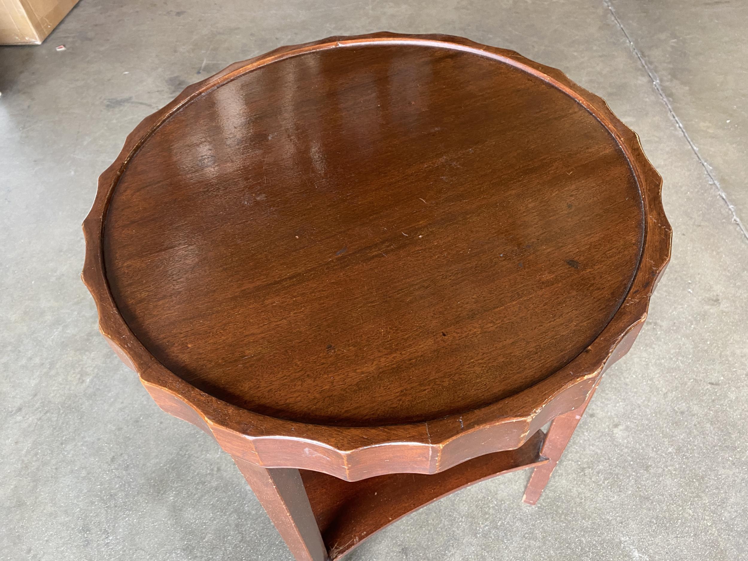 Beautiful streamline coffee table, circa 1930. The Classic Art Deco side table with bottle cap shaped top and second tier for storage of books or accessories.