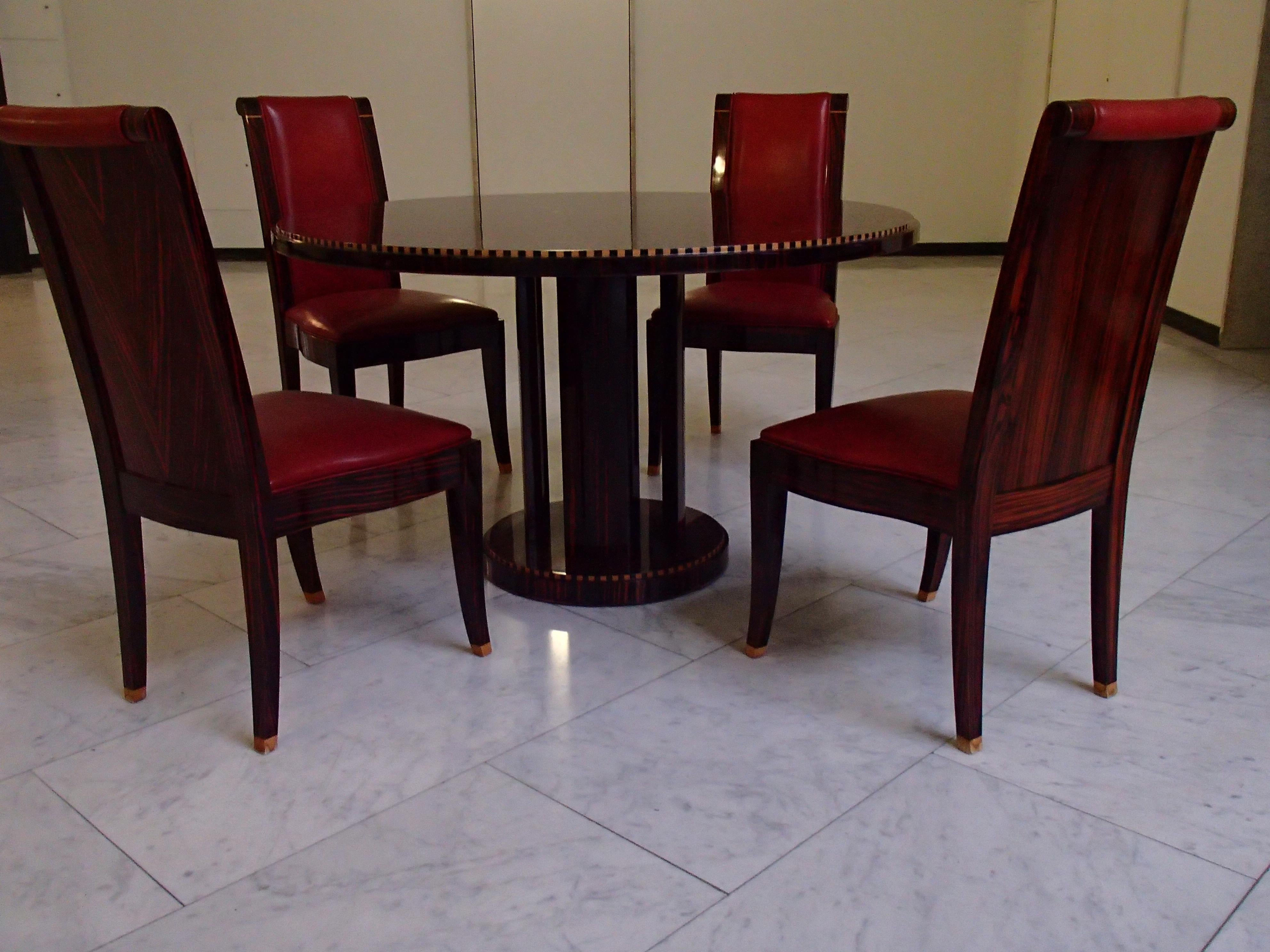 Round Art Deco table with 4 red leather chairs newer production with signs of wear around the table. The top is in good condition. The chairs have also some small hits, but the leather is good.