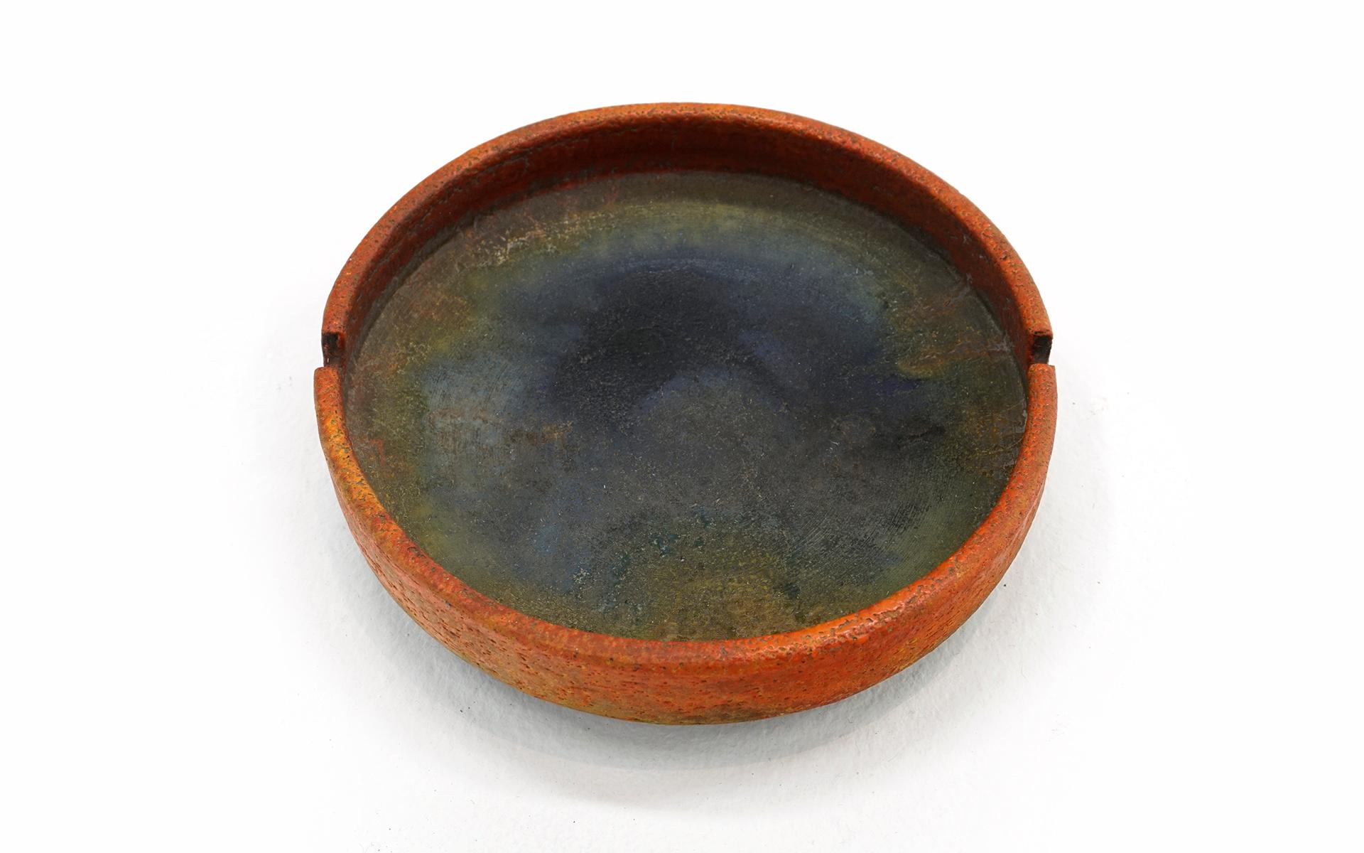 Round Ceramic Ash Tray by Marcello Fantoni. Burnt orange color exterior and black / gray interior. No chips, cracks or repairs. Some signs of wear to inside but no distractions. Signed Fantoni, Italy to the underside.