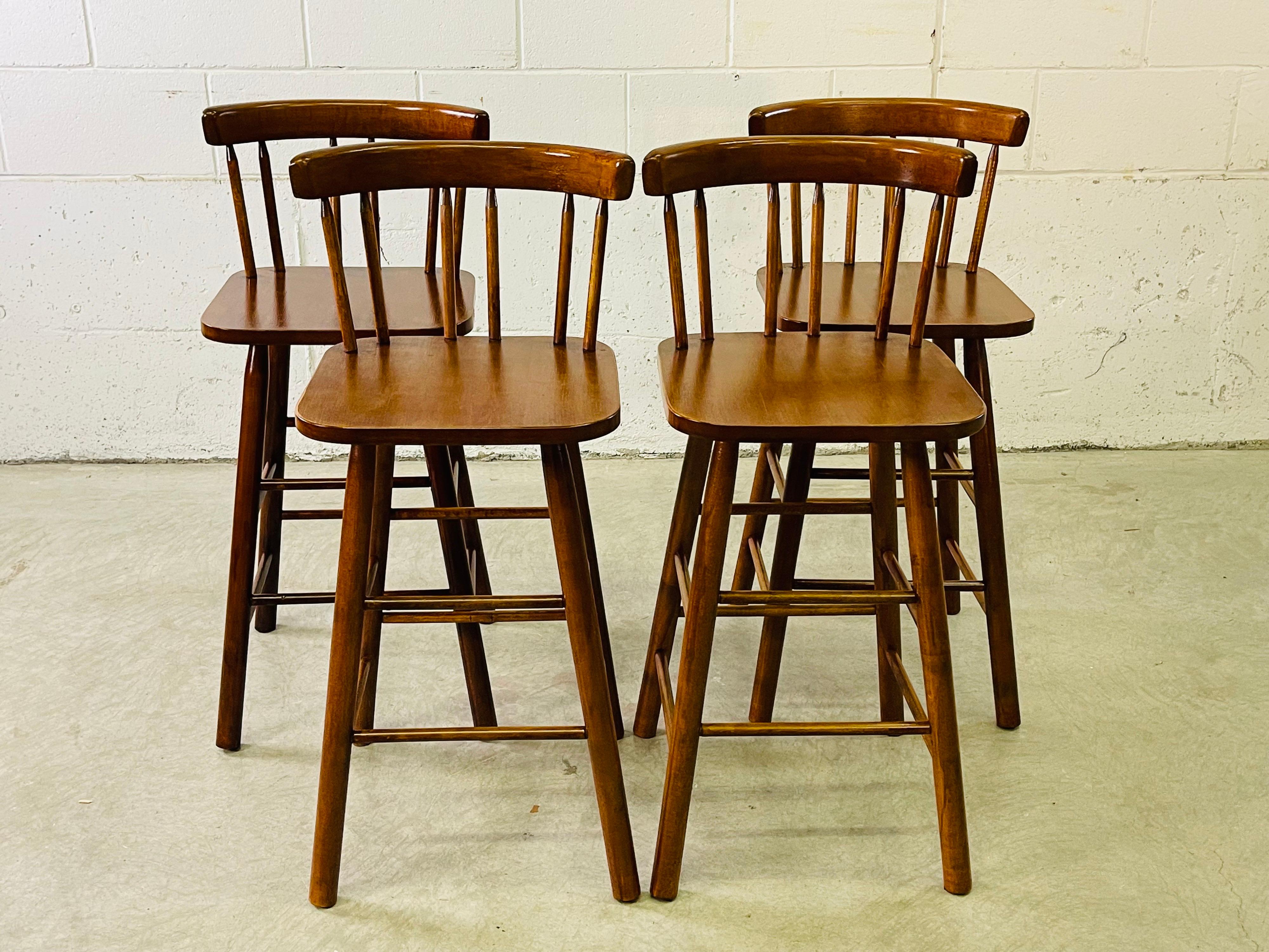 Vintage 1970s set of four round-back wood stools. Newly refinished condition. All the stools are sturdy. No marks.