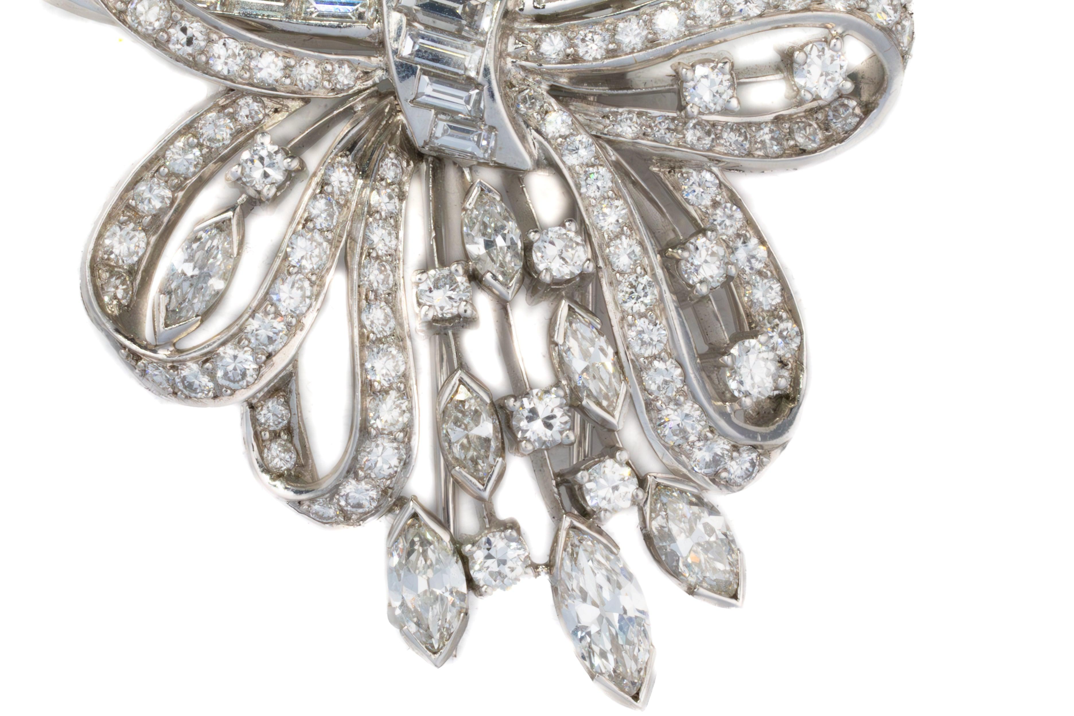 Broche con lazo de diamantes redondos, talla baguette y marquesa

Elegante broche de mediados de siglo elaborado en platino y diseñado como un estilizado lazo entrelazado con un radiante rocío de diamantes. Esta intrincada pieza presenta una