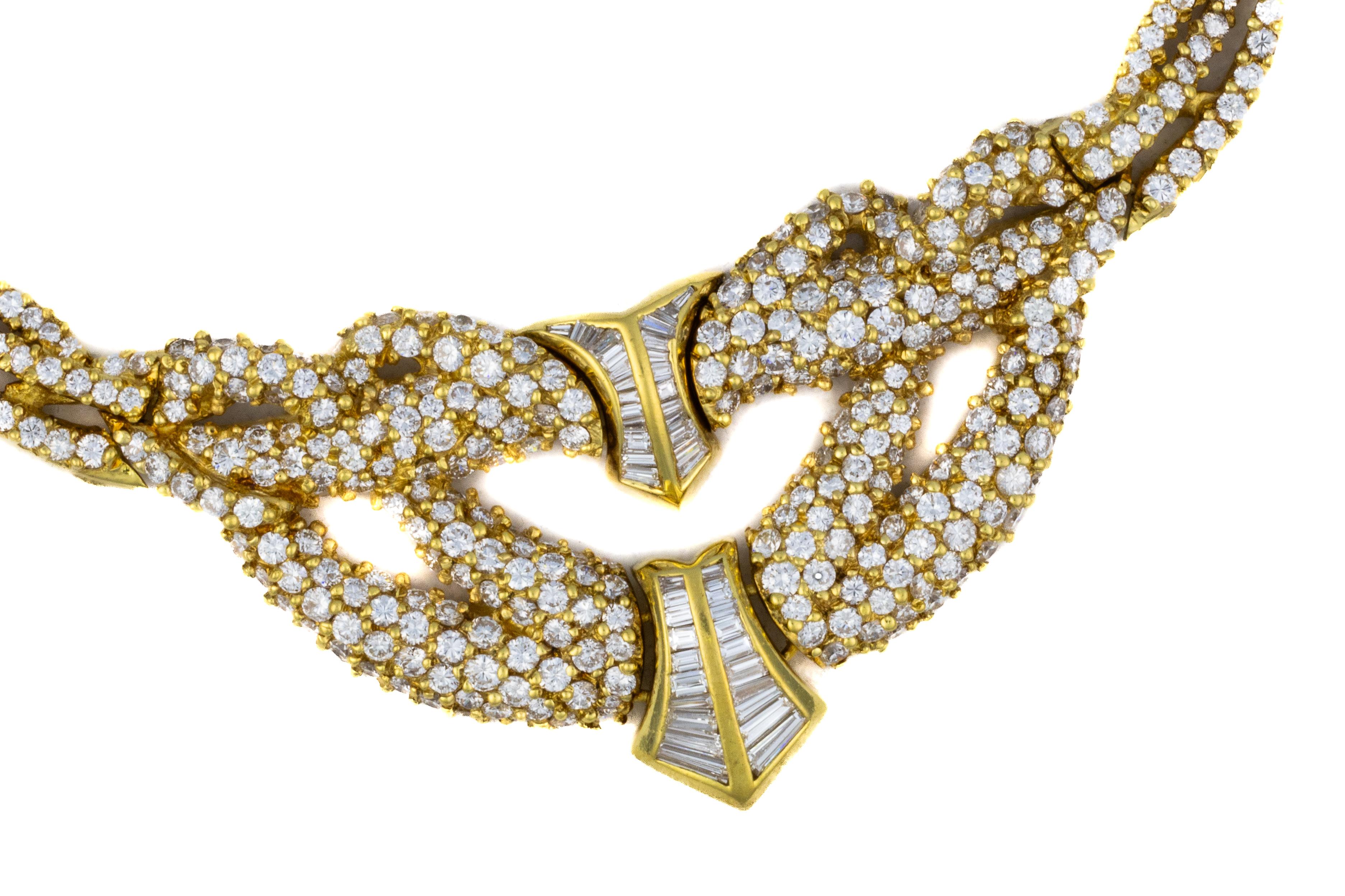 Round & Baguette Diamond Collar Necklace

Description:
An elegant collar necklace crafted in 18 karat yellow gold, designed with a twisted chain leading to a sculptural front section set with diamonds. The centerpiece features an interlaced openwork
