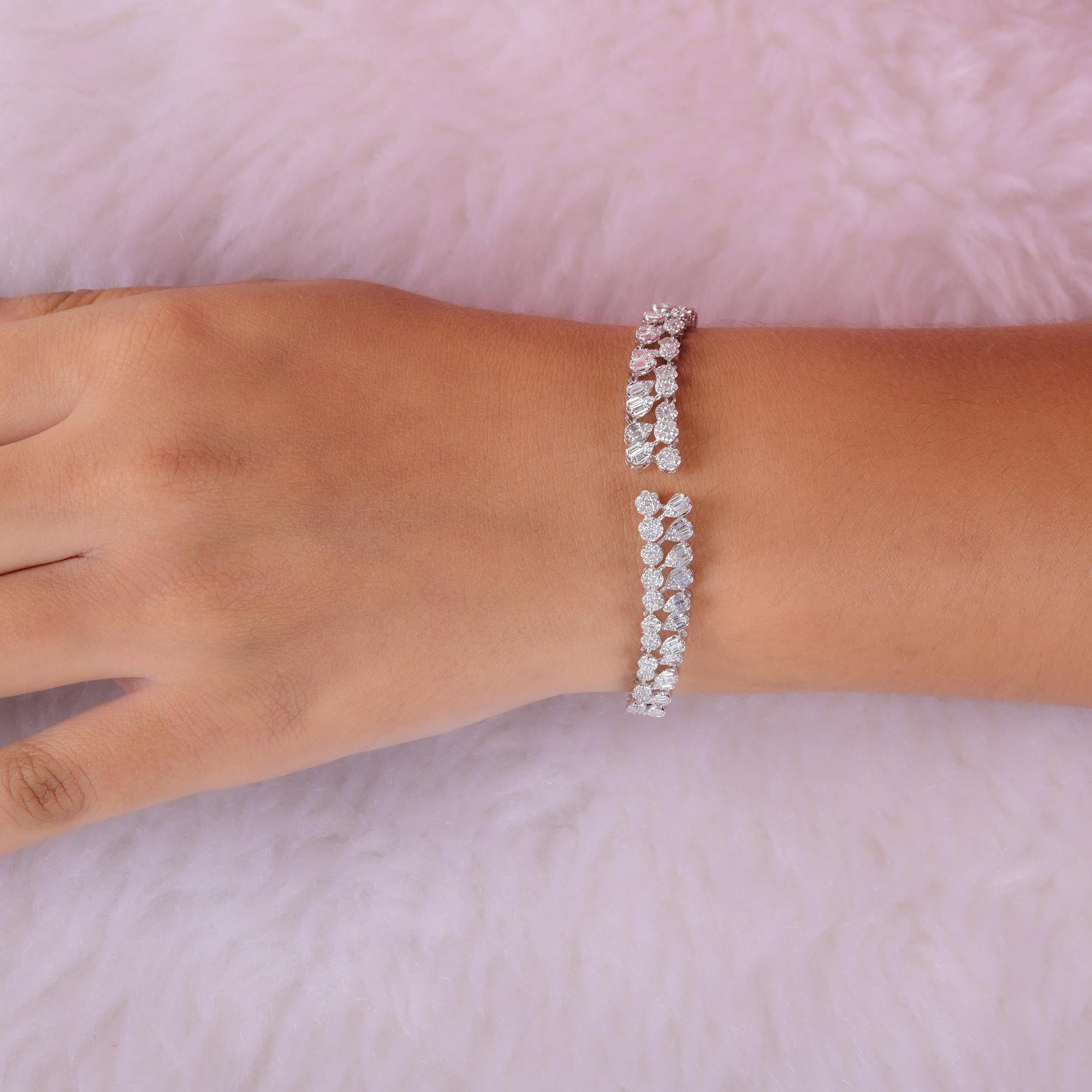 Questo bracciale da polso in oro bianco 14 carati con cluster di diamanti rotondi e a forma di pera incastonati in una sequenza di bracciali aperti. 
I diamanti sono un simbolo universale di eternità e forza. È una pietra di aprile, perfetta per lo