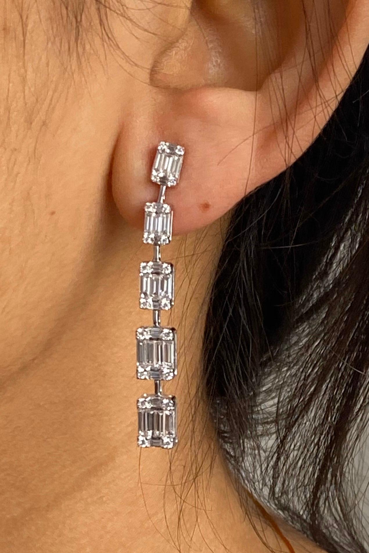 Round & Baguettes Dangling Drop Earrings in 18K White Gold.

Why We Love It:
Glamour goes on and on when it shines brilliantly from Baguette & round diamonds invisible set makes it look like one big Emerald solitaire diamond in 18K white gold