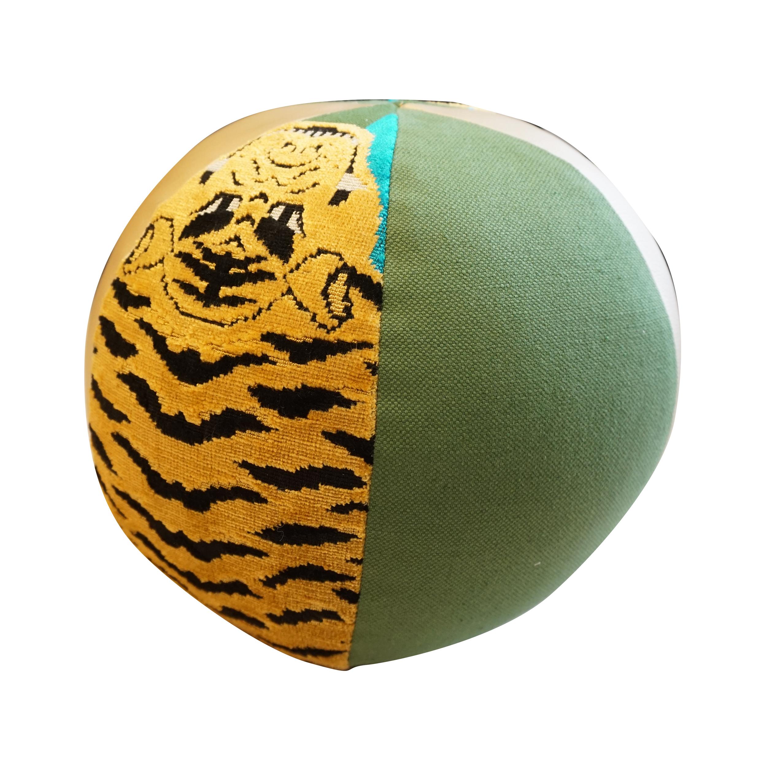 This round ball pillow has an alternating fabric pattern like a beach ball. The stunning designer fabric on this pillow is Schumacher’s Jokhang Tiger velvet, and it's paired with golden vinyl and green cotton blend fabrics. All pillows are handmade