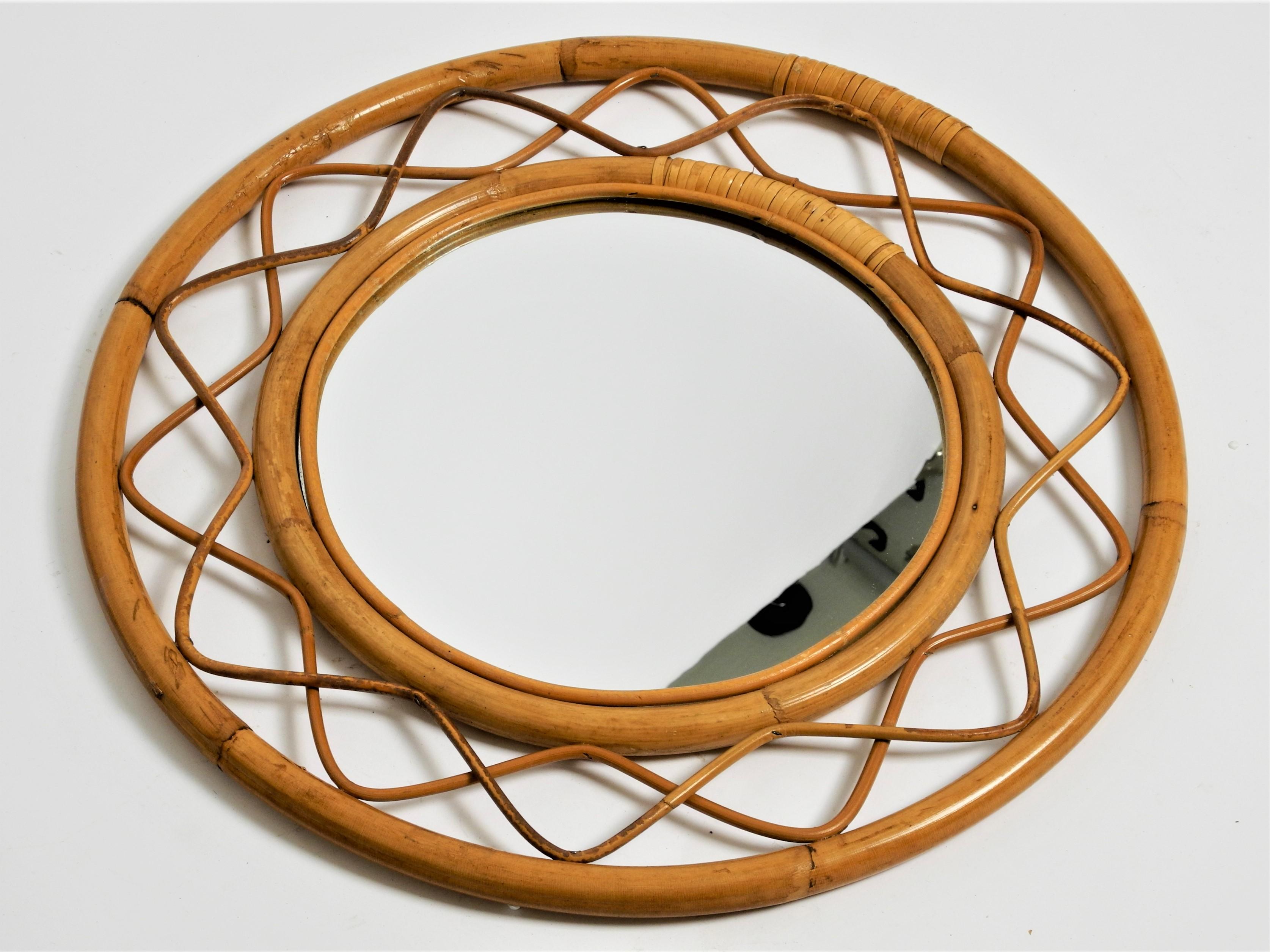 Vintage round bamboo rattan mirror with wooden back panel, Italy, 70s.

Dimensions:
Total diameter 50cm/19,7inch
Diameter of mirror 28,5cm/11,2inch
Depth 2.5cm/1.0inch.

The mirror is in a very good vintage condition with less signs of wear.