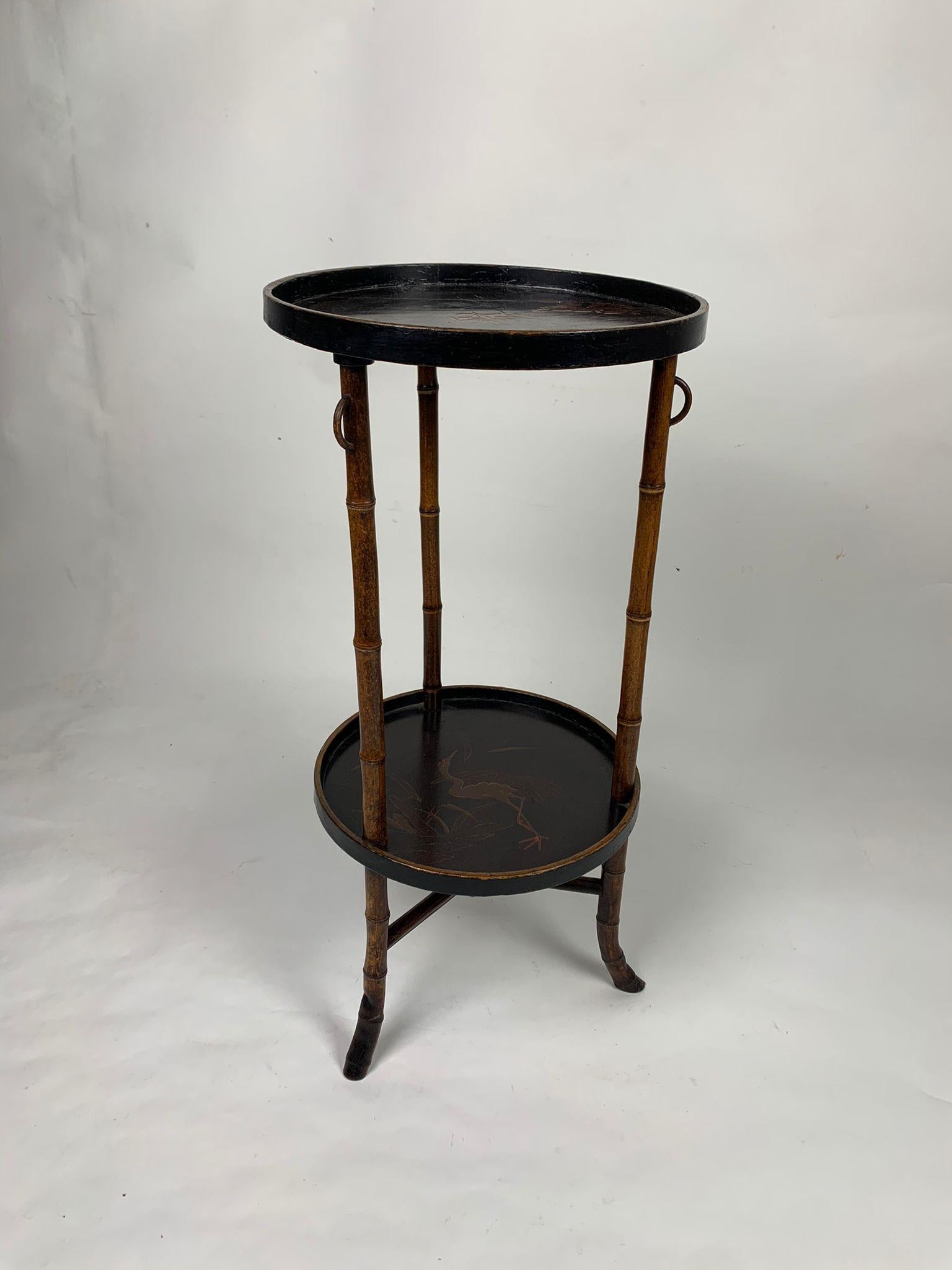 Round bamboo table with decorations, Asian art.
Bamboo table with two round shelves with decorations. 
The first shelf depicts an ox and a naturalistic landscape, the second a heron near a lake. 

Very good condition
Measurements: 26 x 76 h cm 

