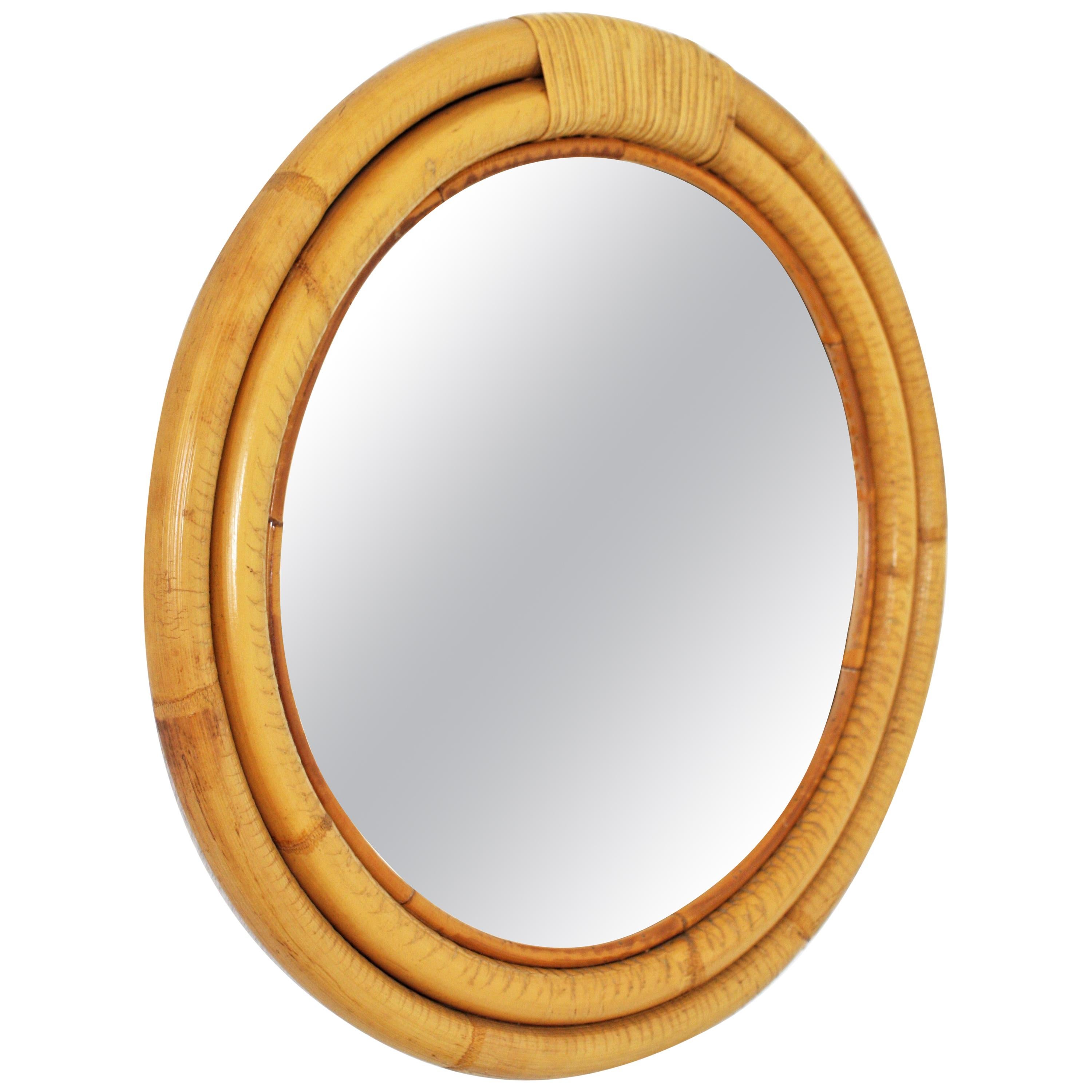 Splendido specchio da parete rotondo in bambù del Mid-Century Modern con dettaglio in rattan avvolto sulla parte superiore.
Questo specchio ricorda i disegni di Paul Frankl.
Due cornici circolari concentriche in bambù con una decorazione in vimini