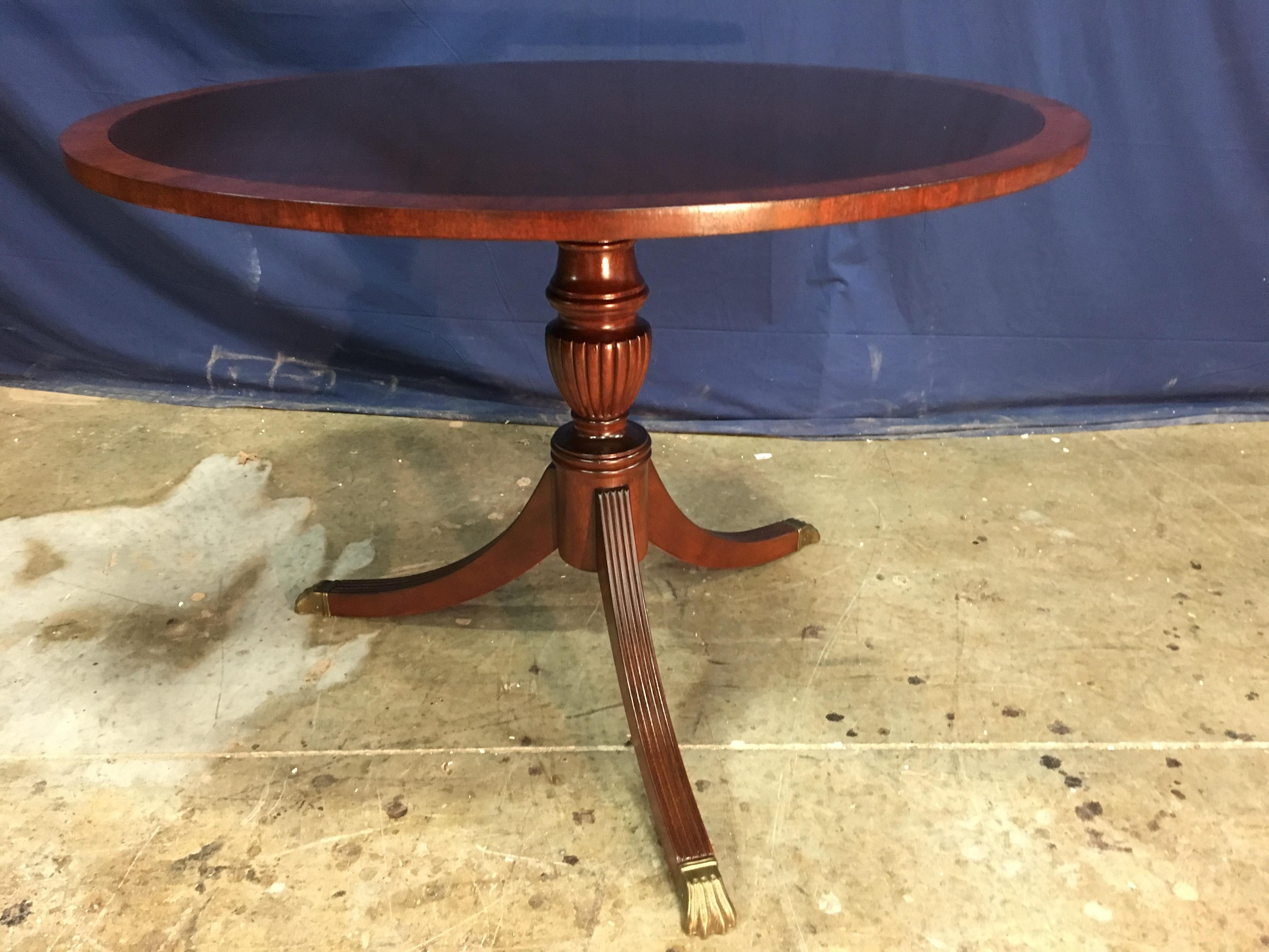 This is made-to-order round traditional mahogany accent/foyer table made in the Leighton Hall shop. It features a field of cathedral mahogany with a contrasting mahogany border. It has a hand rubbed and polished semigloss finish. The pedestal has