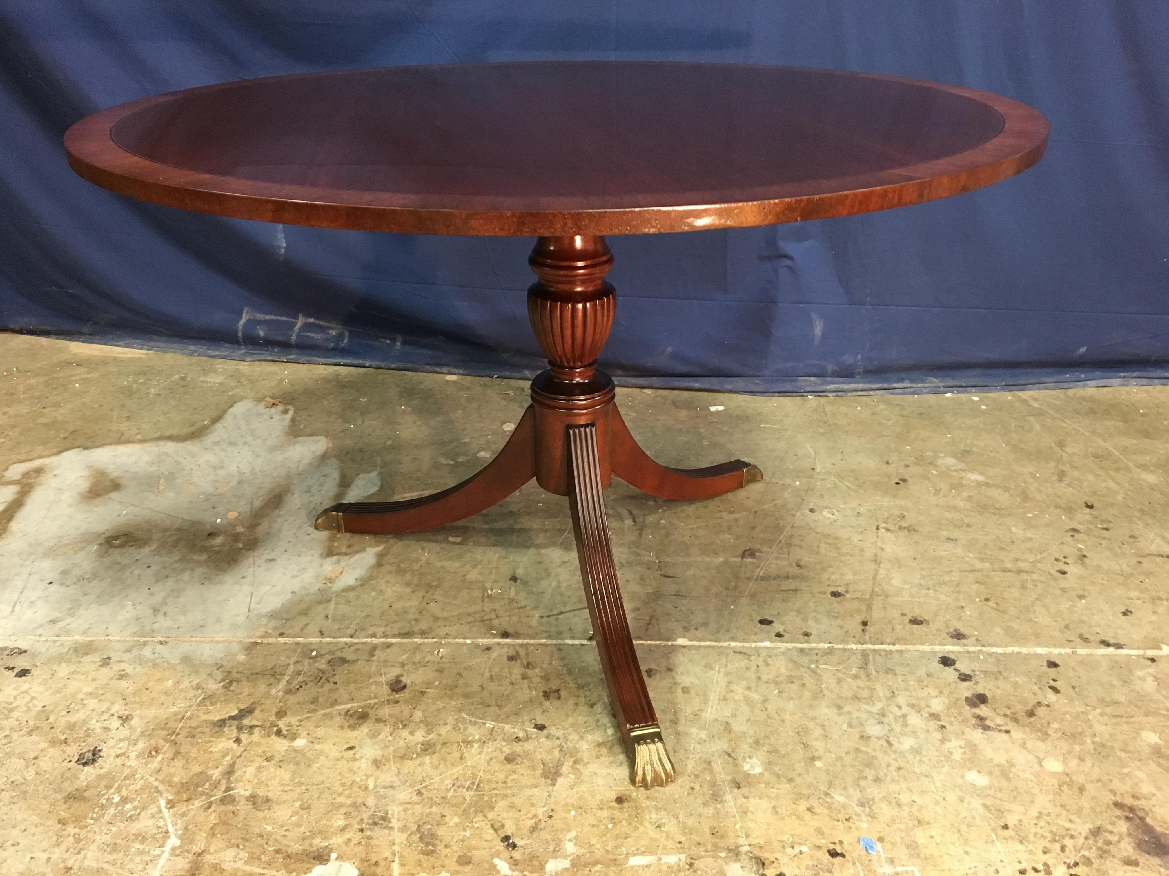 This is made-to-order round traditional mahogany accent/foyer table made in the Leighton Hall shop. It features a field of cathedral mahogany with a contrasting mahogany border. It has a hand rubbed and polished semigloss finish. The pedestal has