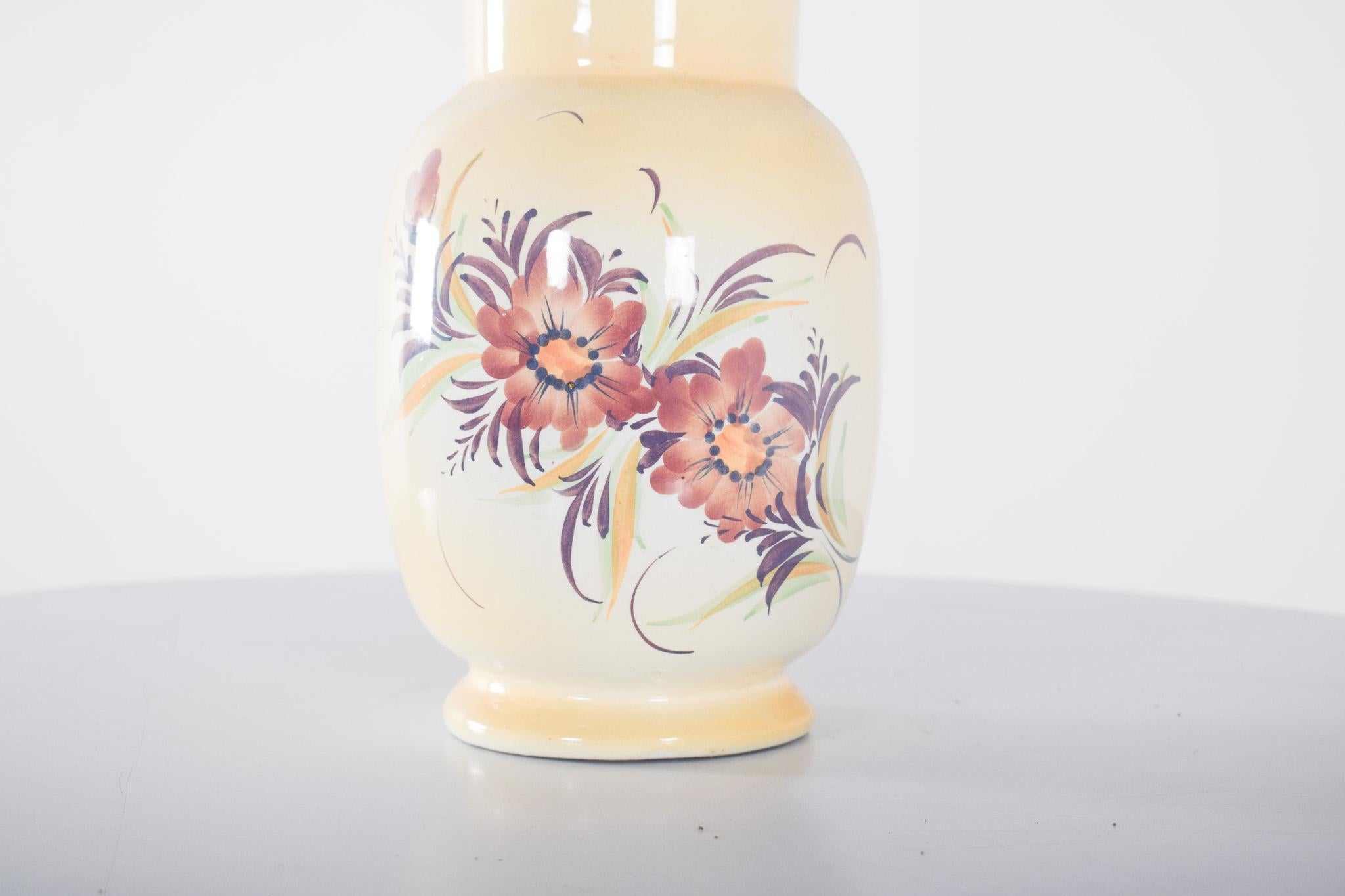 Beige ceramic jug. Round, with a slight widening at the base and mouth, which offers an elegant and functional design at the same time. The surface is enamelled in a light beige tone, with a slight gradient that intensifies at the bottom. The main
