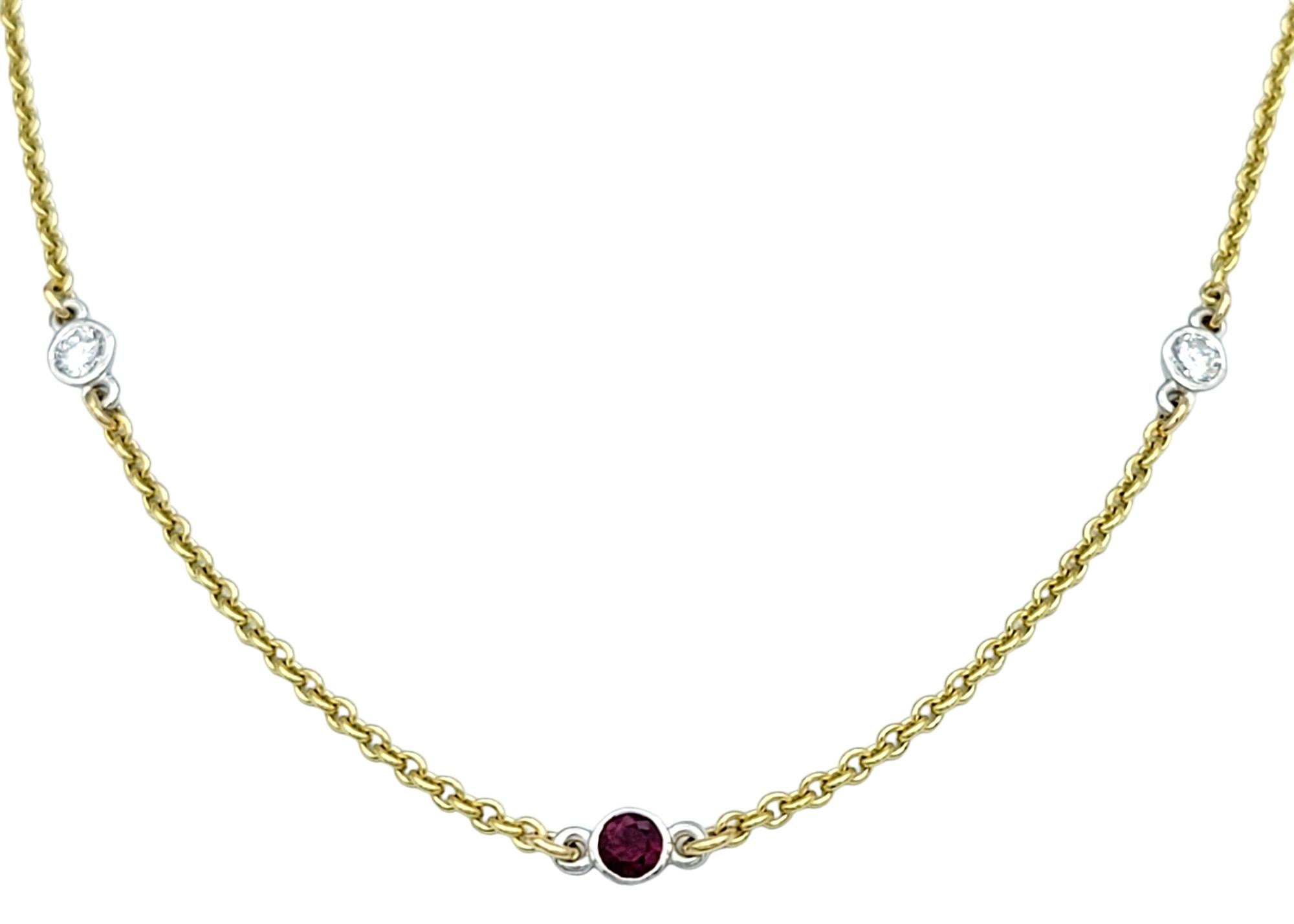 This stunning chain station necklace features alternating diamond and ruby bezel stations set in luxurious 18 karat yellow gold. Each station showcases a sparkling round diamond or a vibrant round ruby, creating a striking contrast along the length